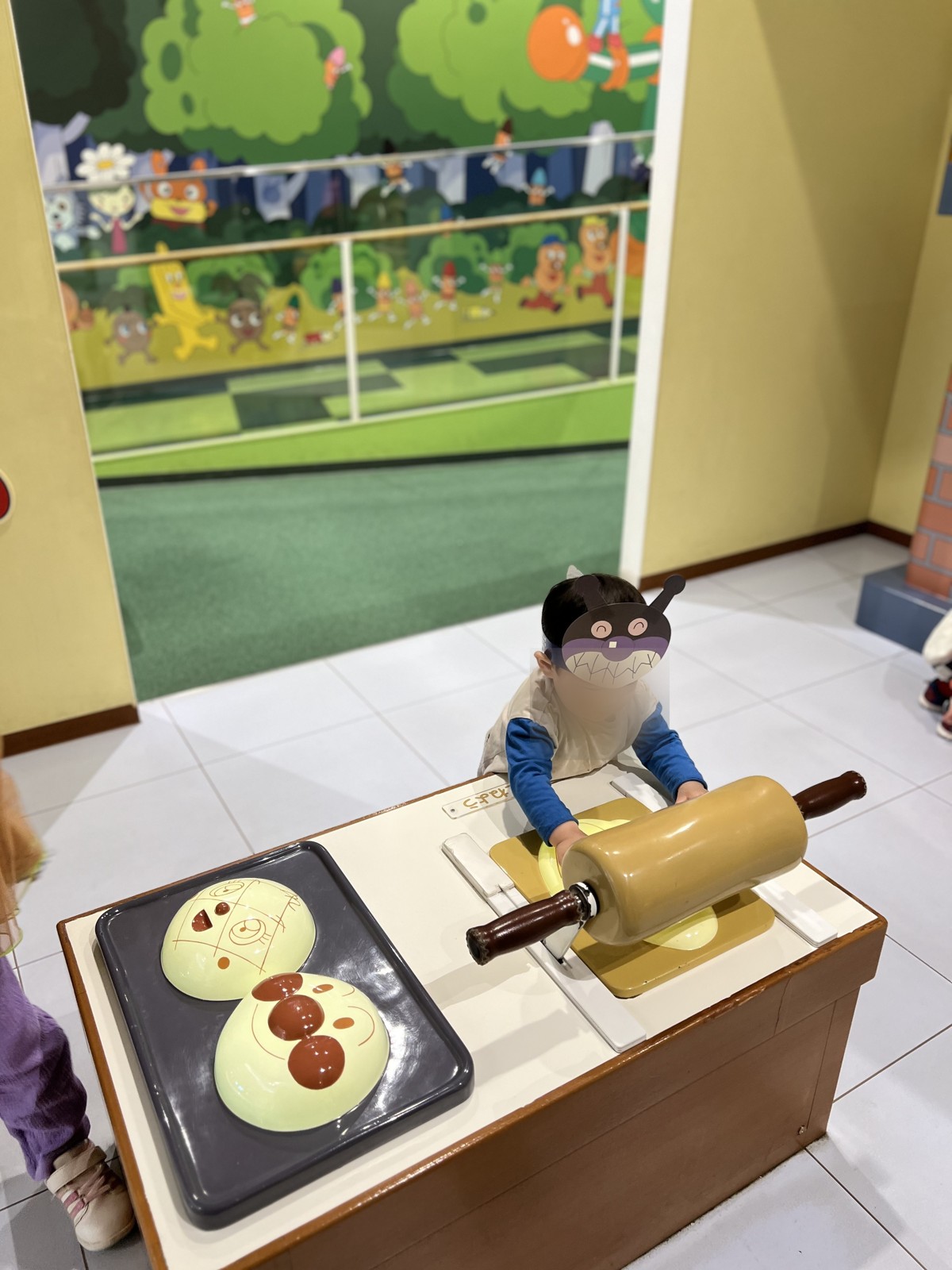 パン工場の大きなめん棒を転がす子ども