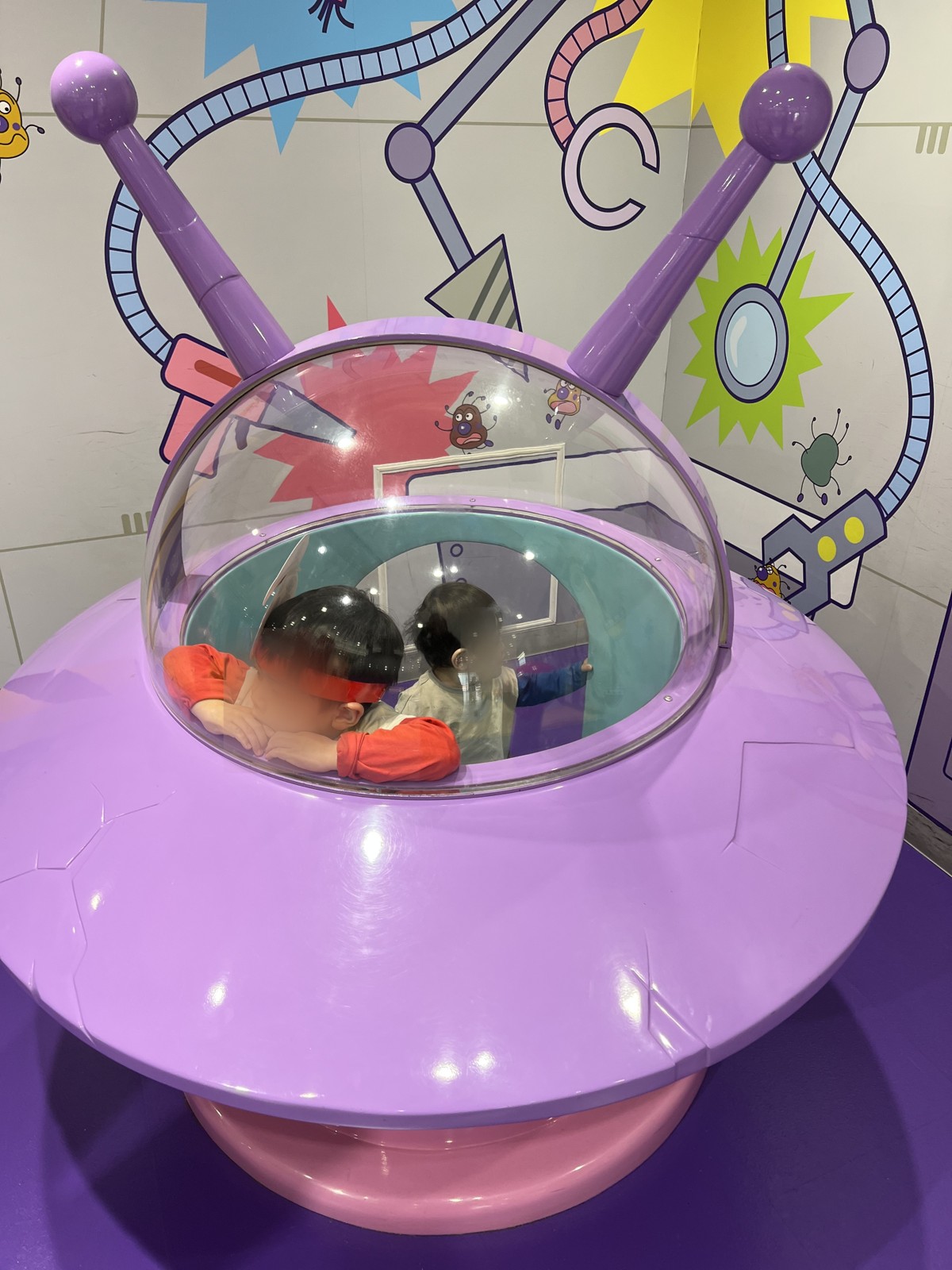 ばいきんまんのUFO型の乗り物に入る子ども