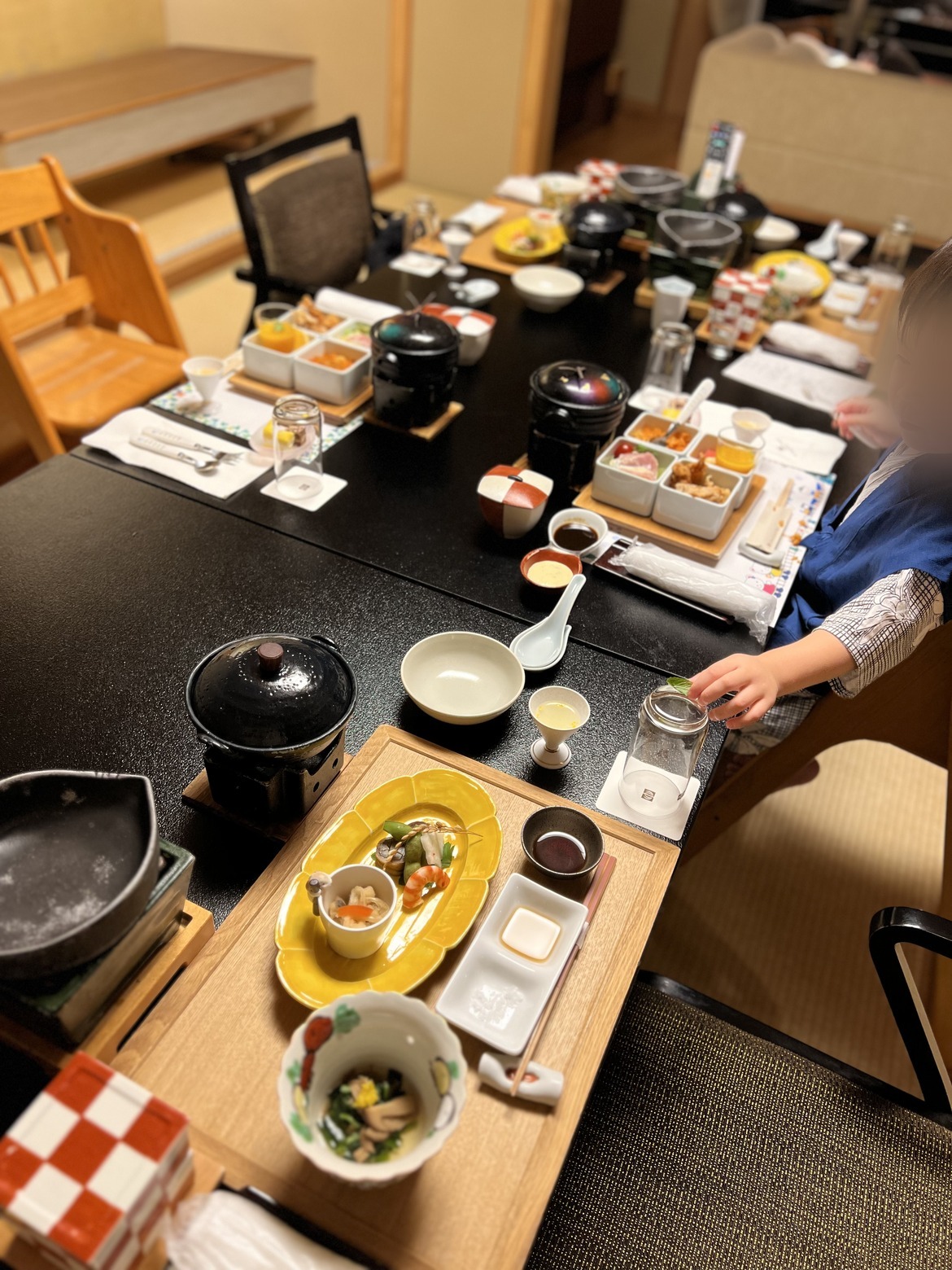 夕食の会席が並んだテーブル。子ども用のいすが置かれている