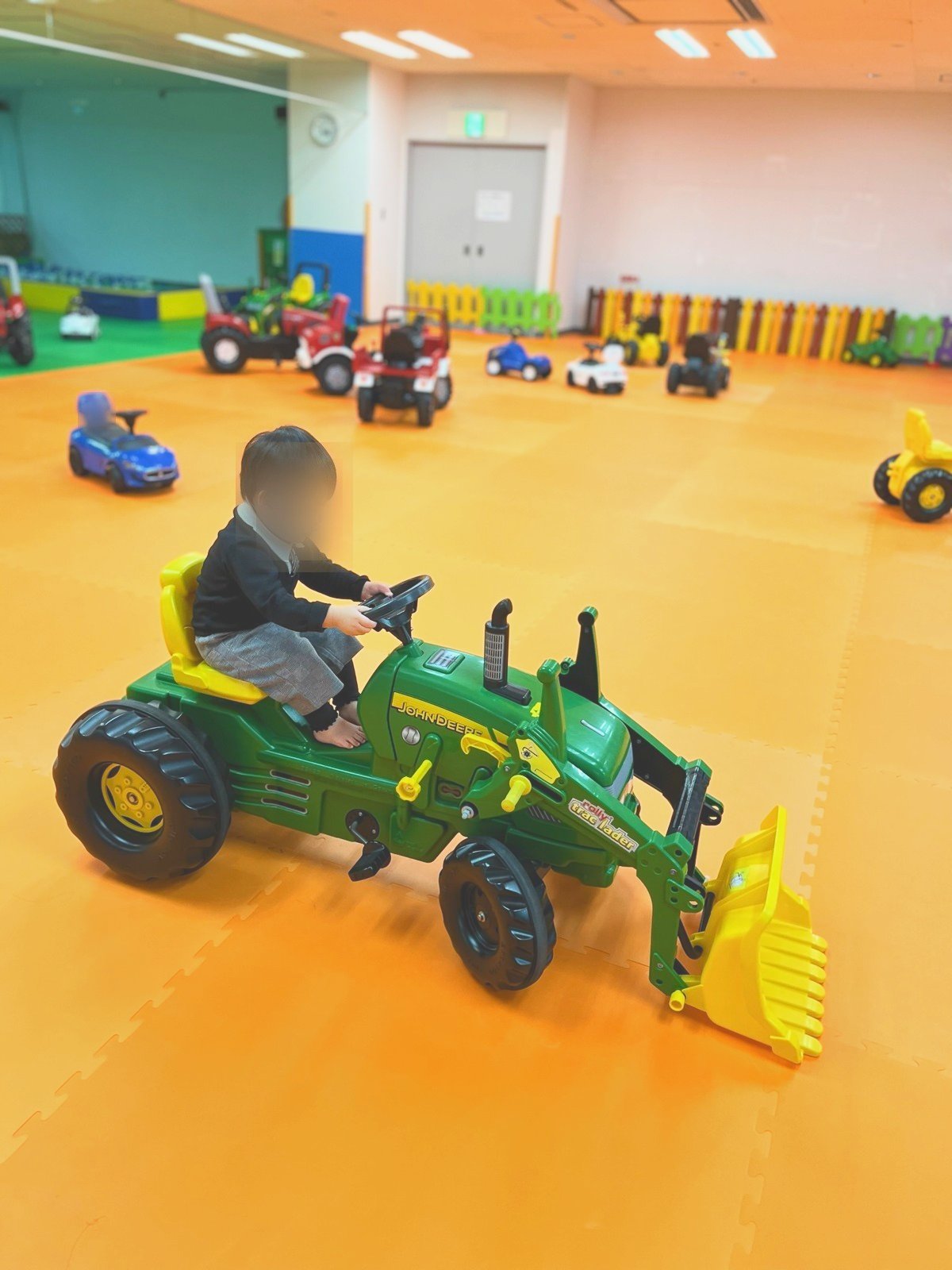 トラクターの乗り物に乗る子ども