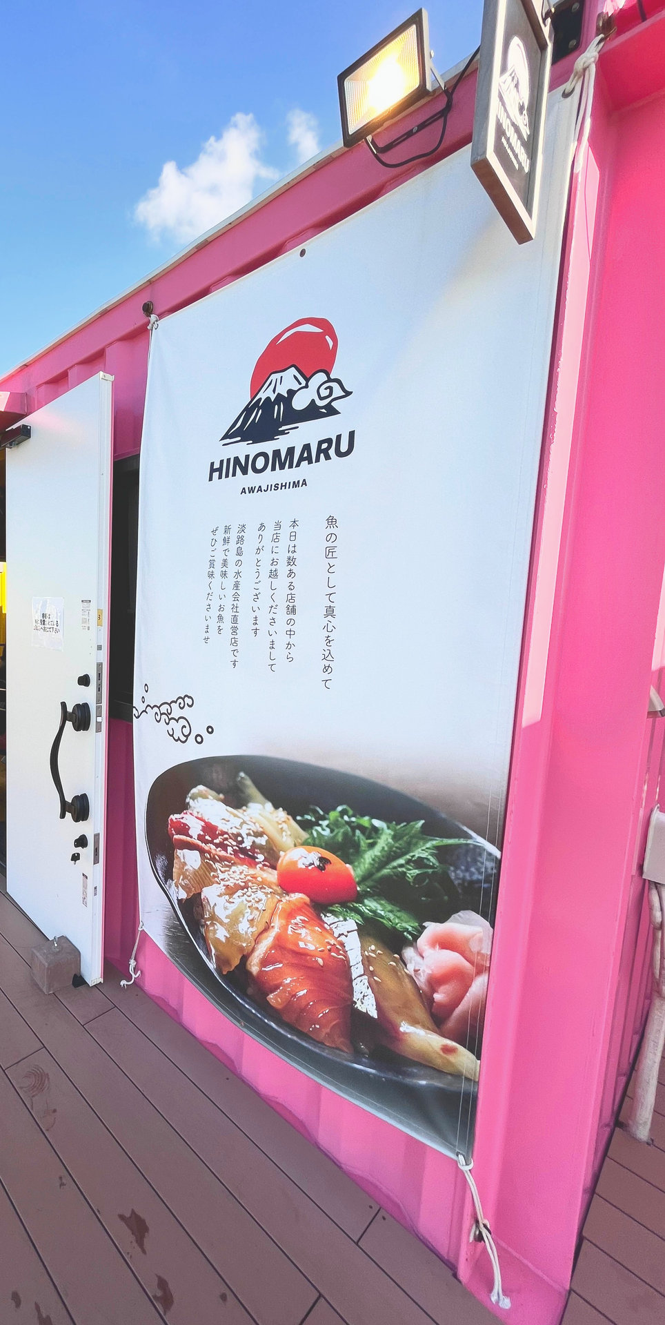ピンク色のコンテナにあるHINOMARUの看板
