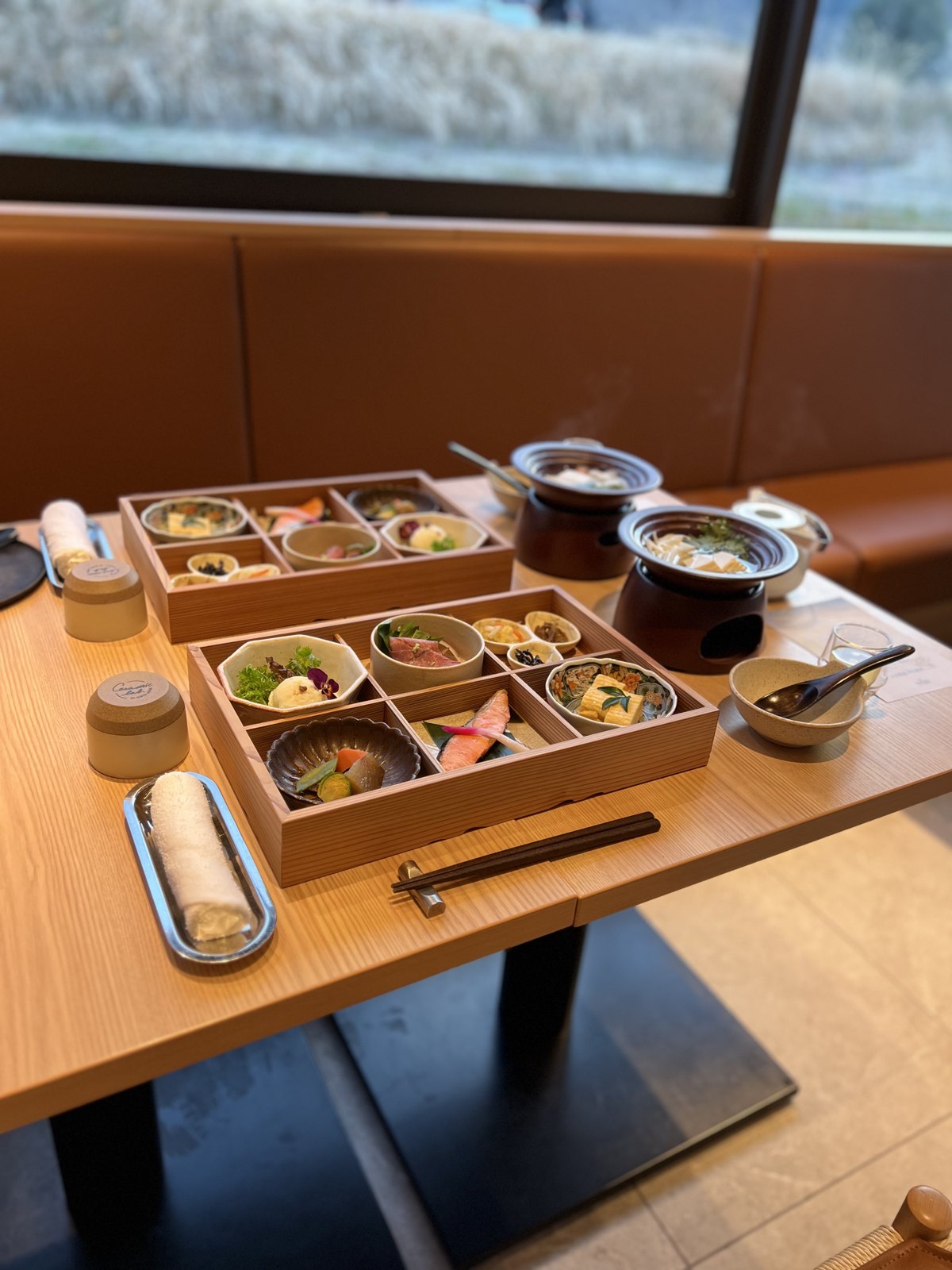 木箱に小鉢が並ぶ和食の朝ごはんと、湯豆腐の小鍋