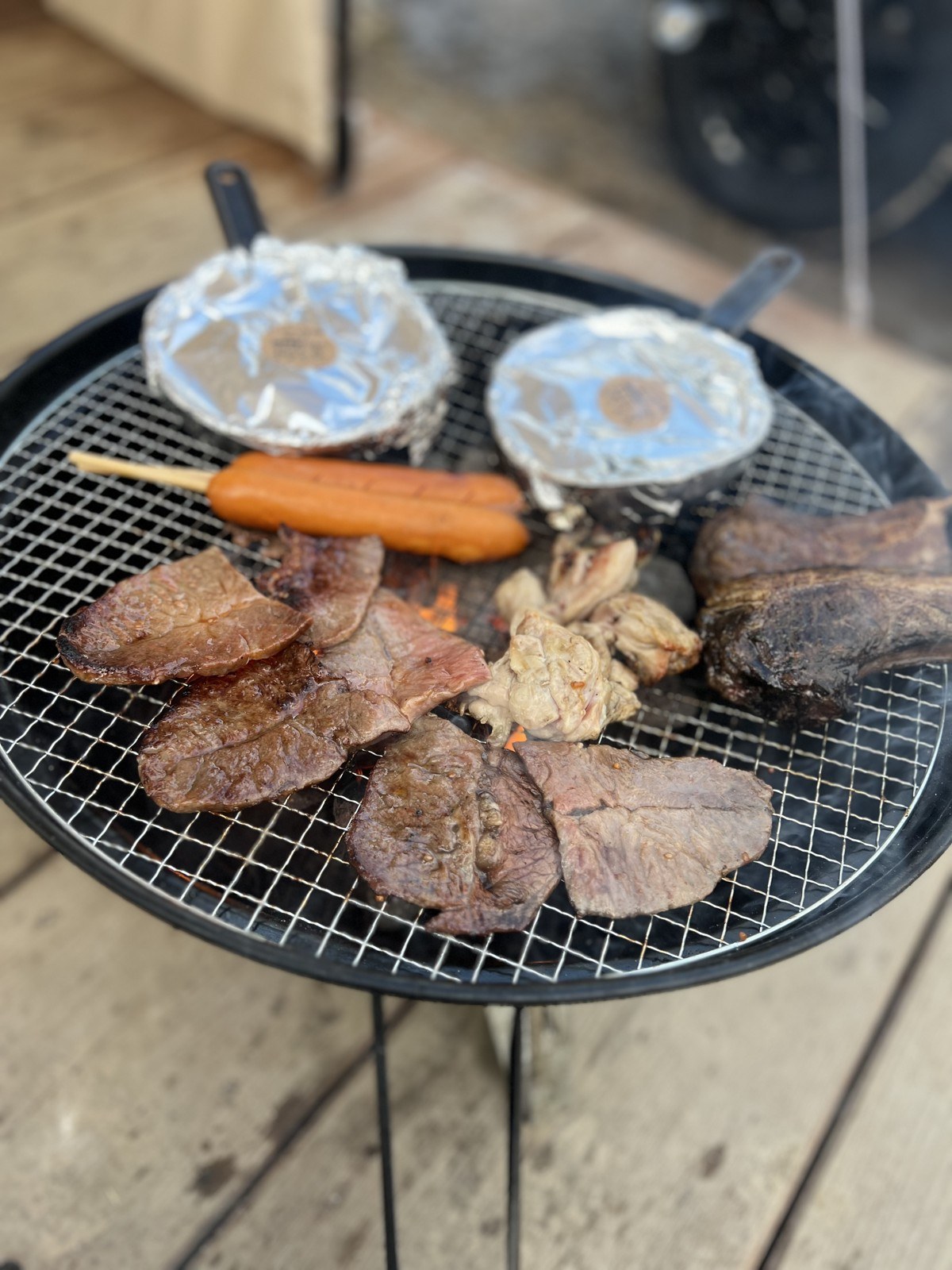 焚き火台の網で焼く肉とホイル焼き