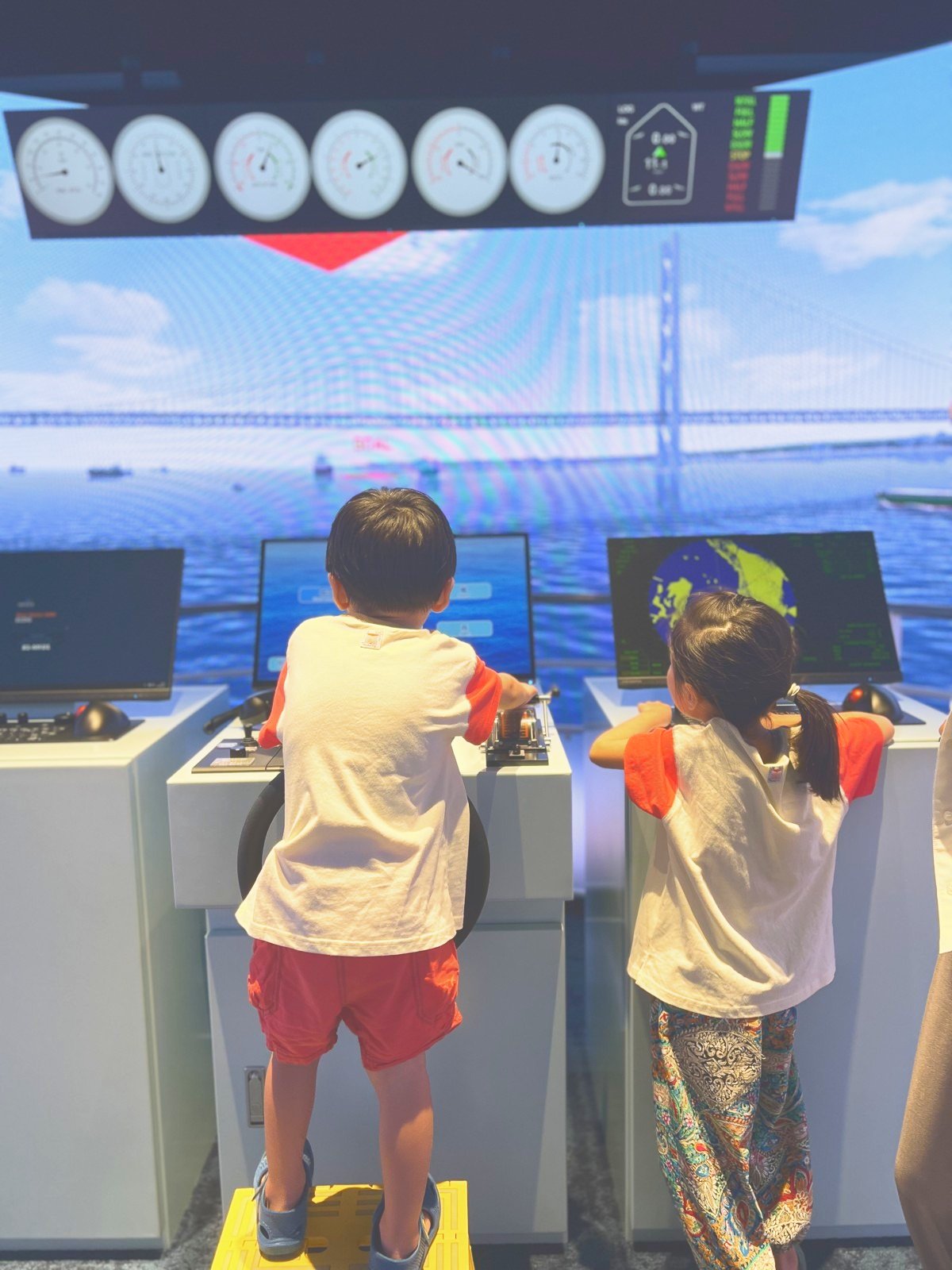 操船シミュレータのコンソールを操作する子どもたち
