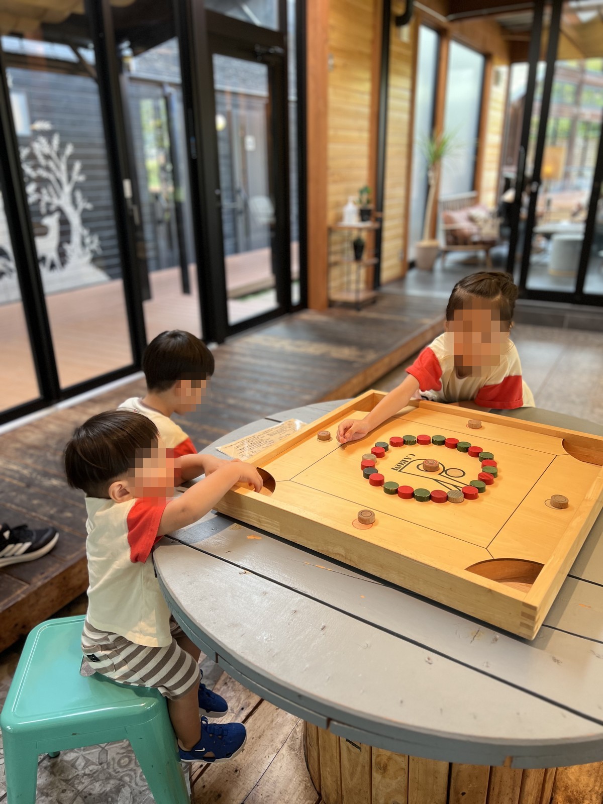 木のテーブルゲームで遊ぶ子どもたち