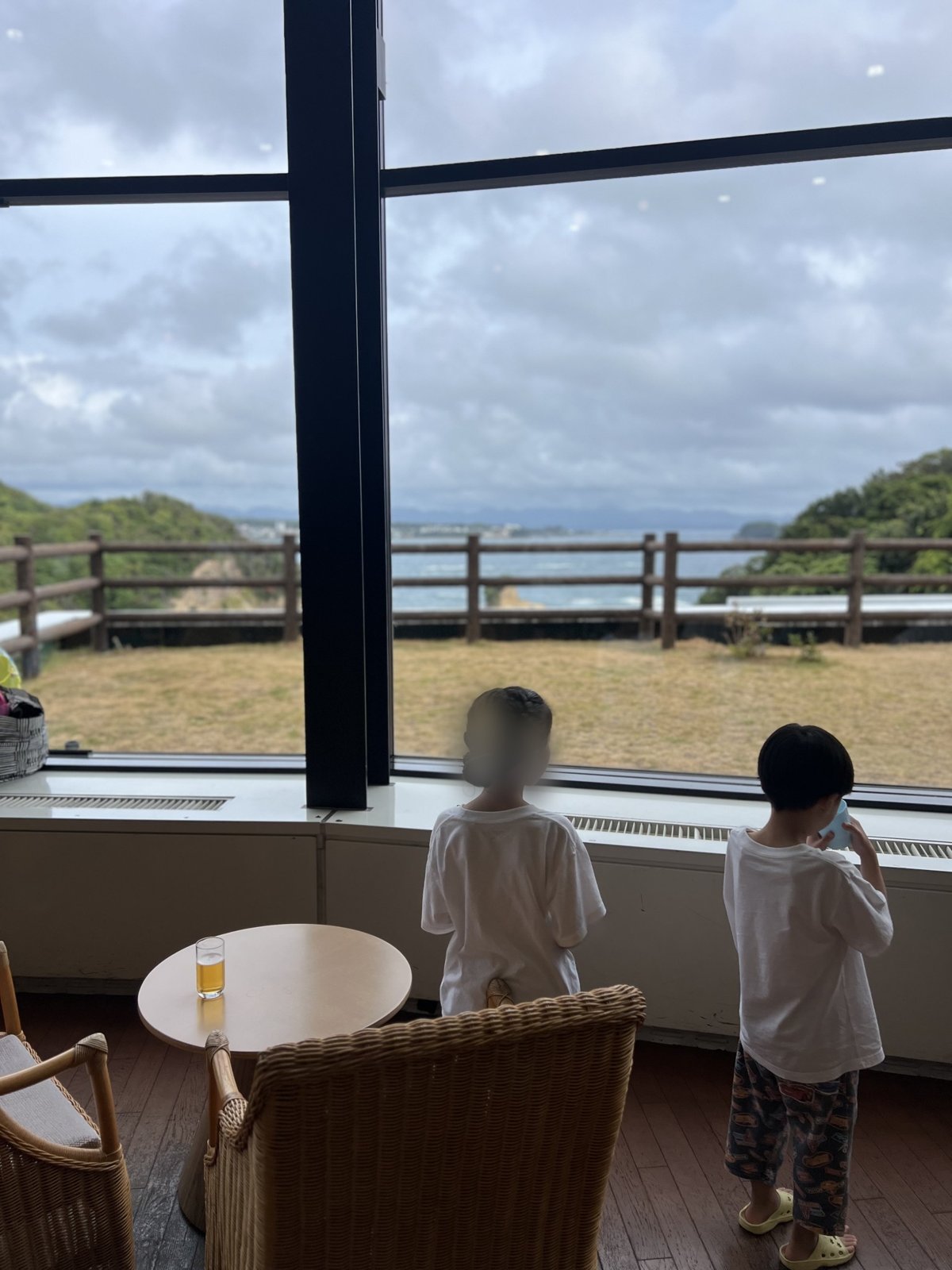 ラウンジの大きな窓から海を見る子どもたち