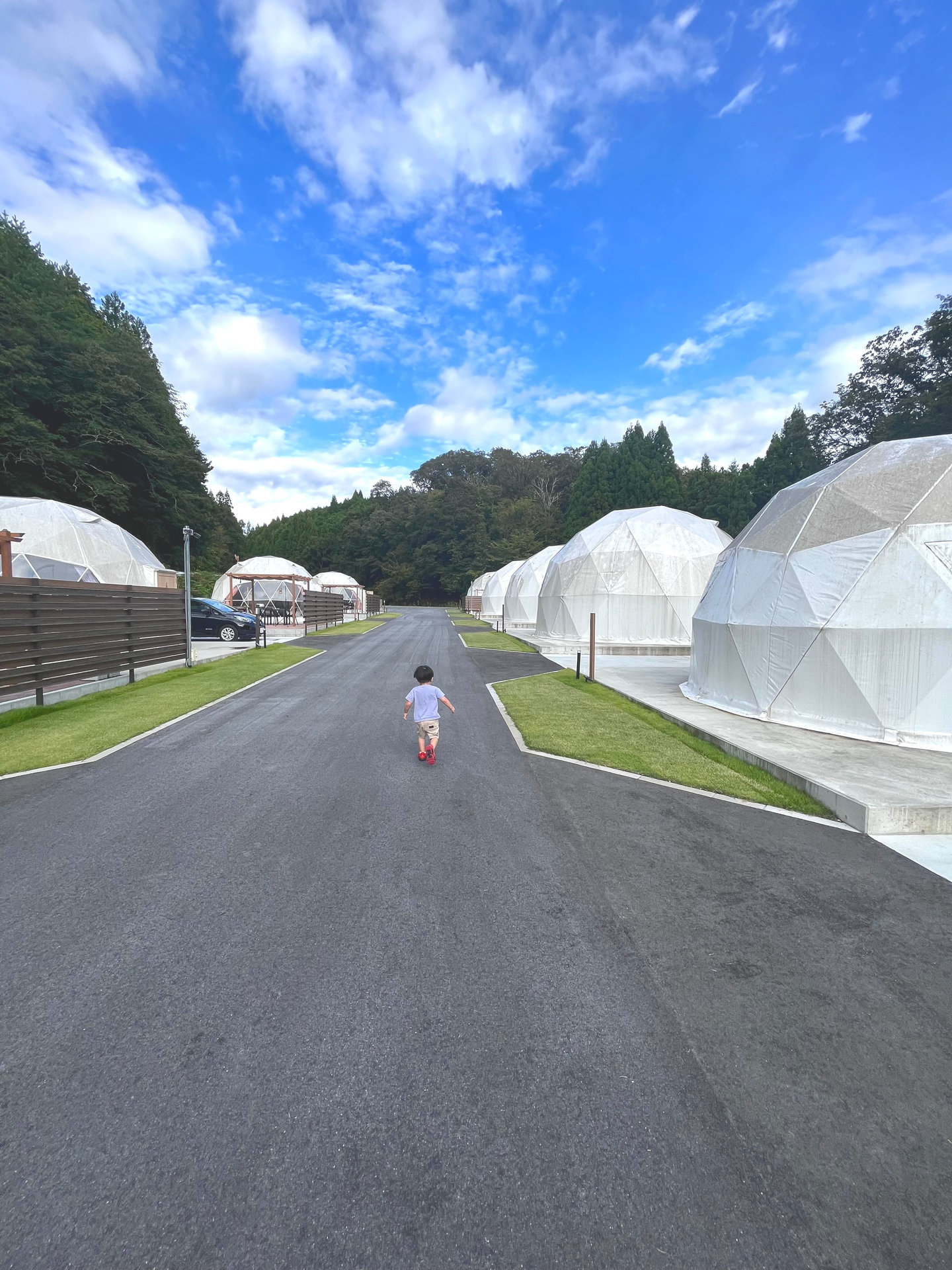 ドームテントが並ぶ通路と子どもの後ろ姿