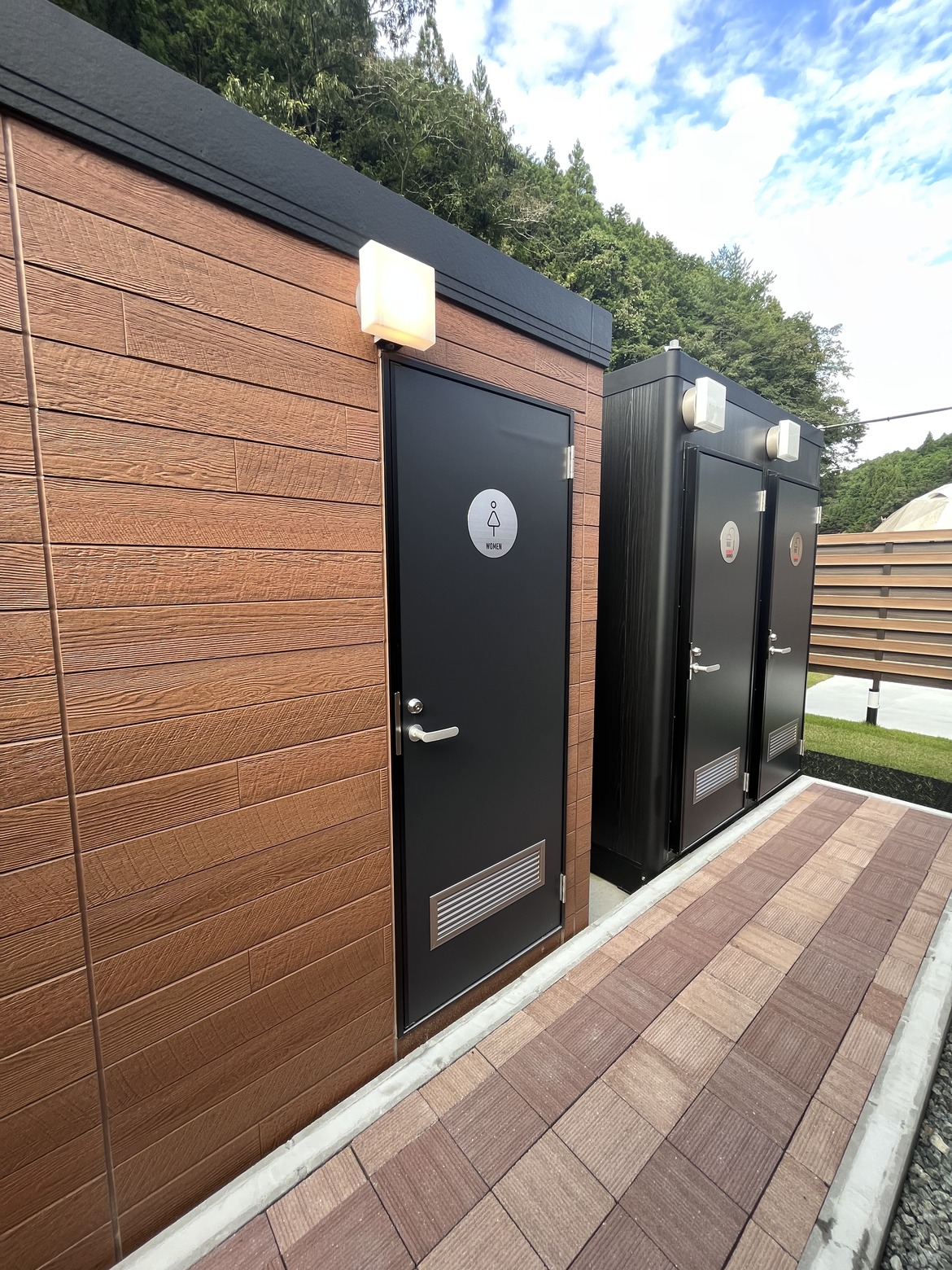 木目の扉が並ぶシャワー・トイレ棟