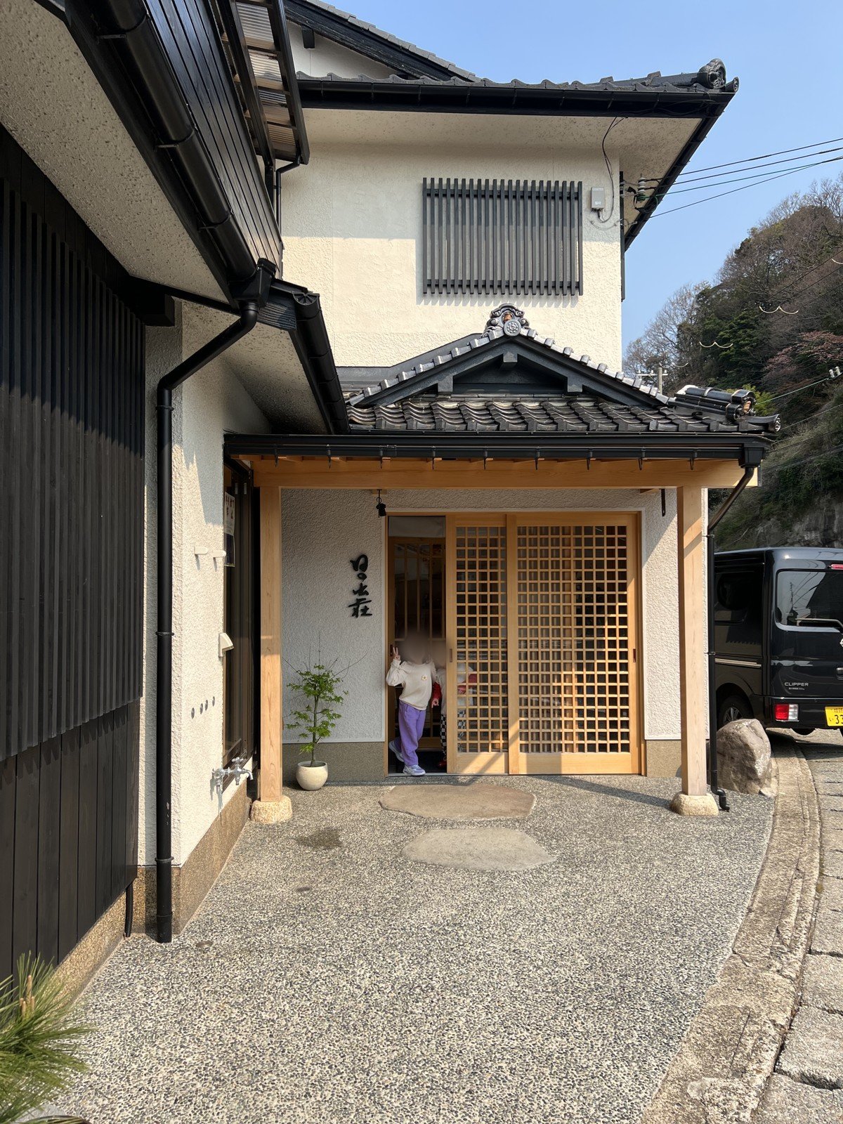 格子の引き戸がある玄関から顔を出す子どもたち