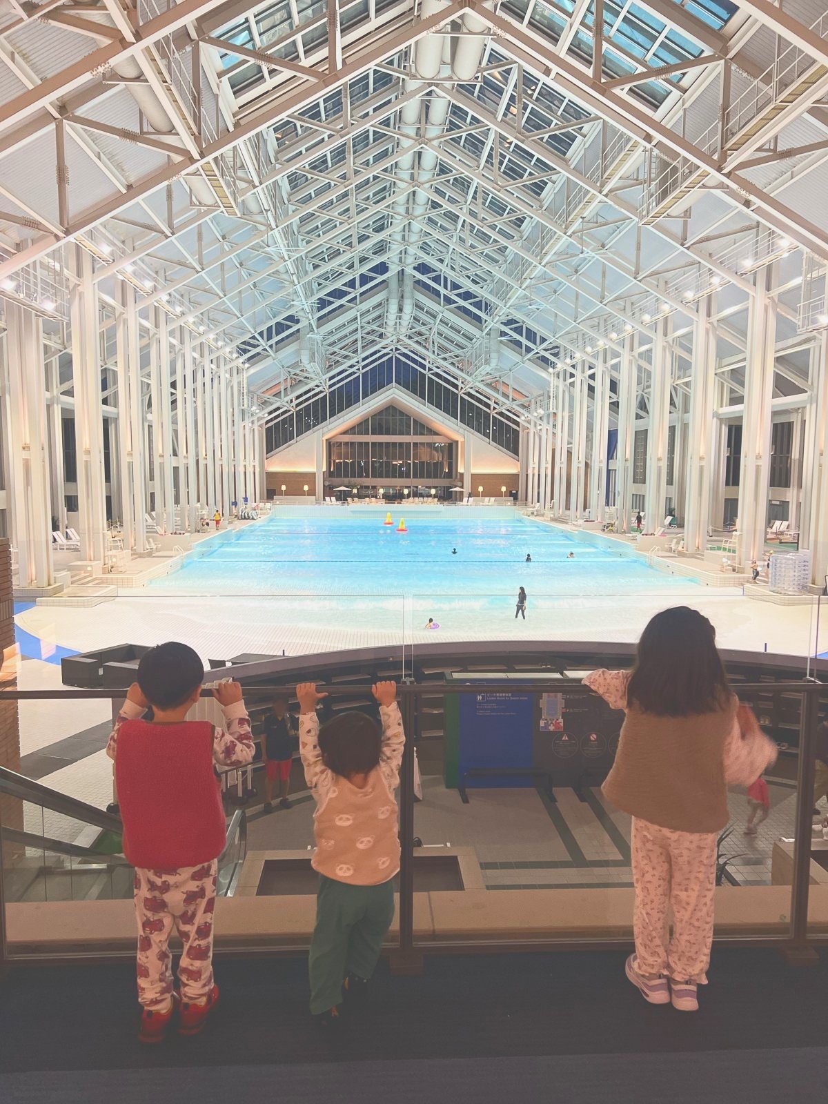 夕方のミナミナビーチをガラス越しに見る子どもたち