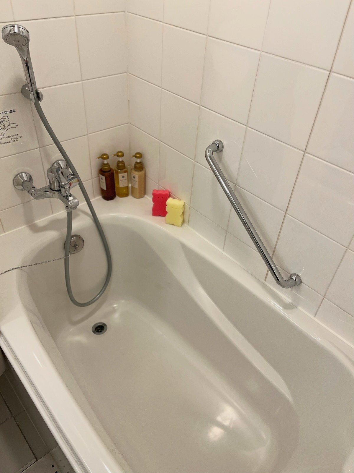 手すりのついた浴槽と、くまの形のスポンジ2つ
