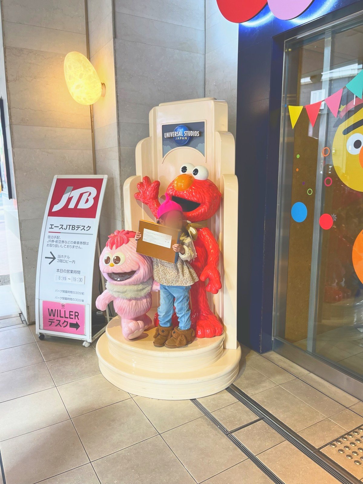 エントランスのキャラクター像の前に立つ子ども
