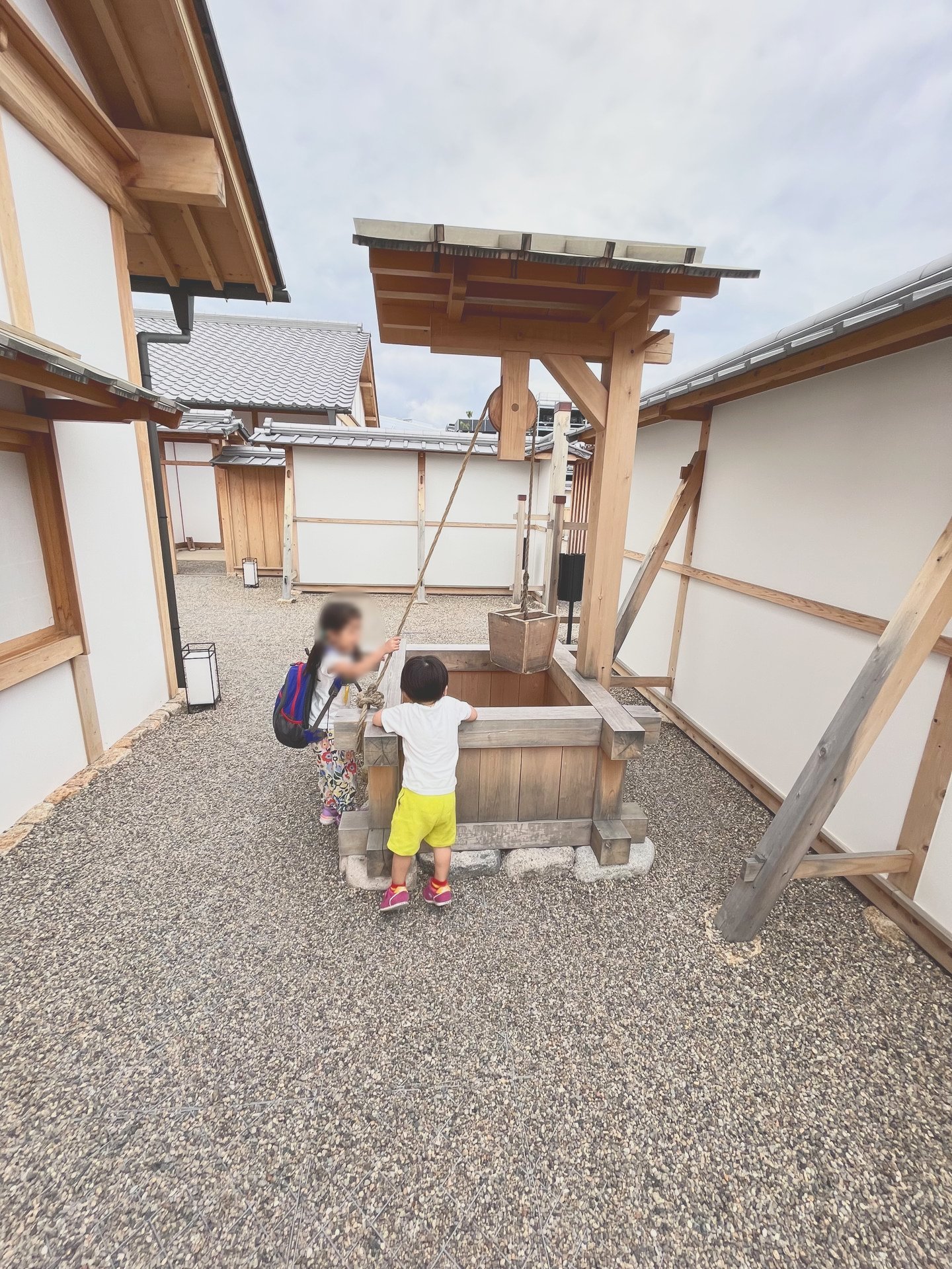 屋外の井戸のそばにいる子どもたち