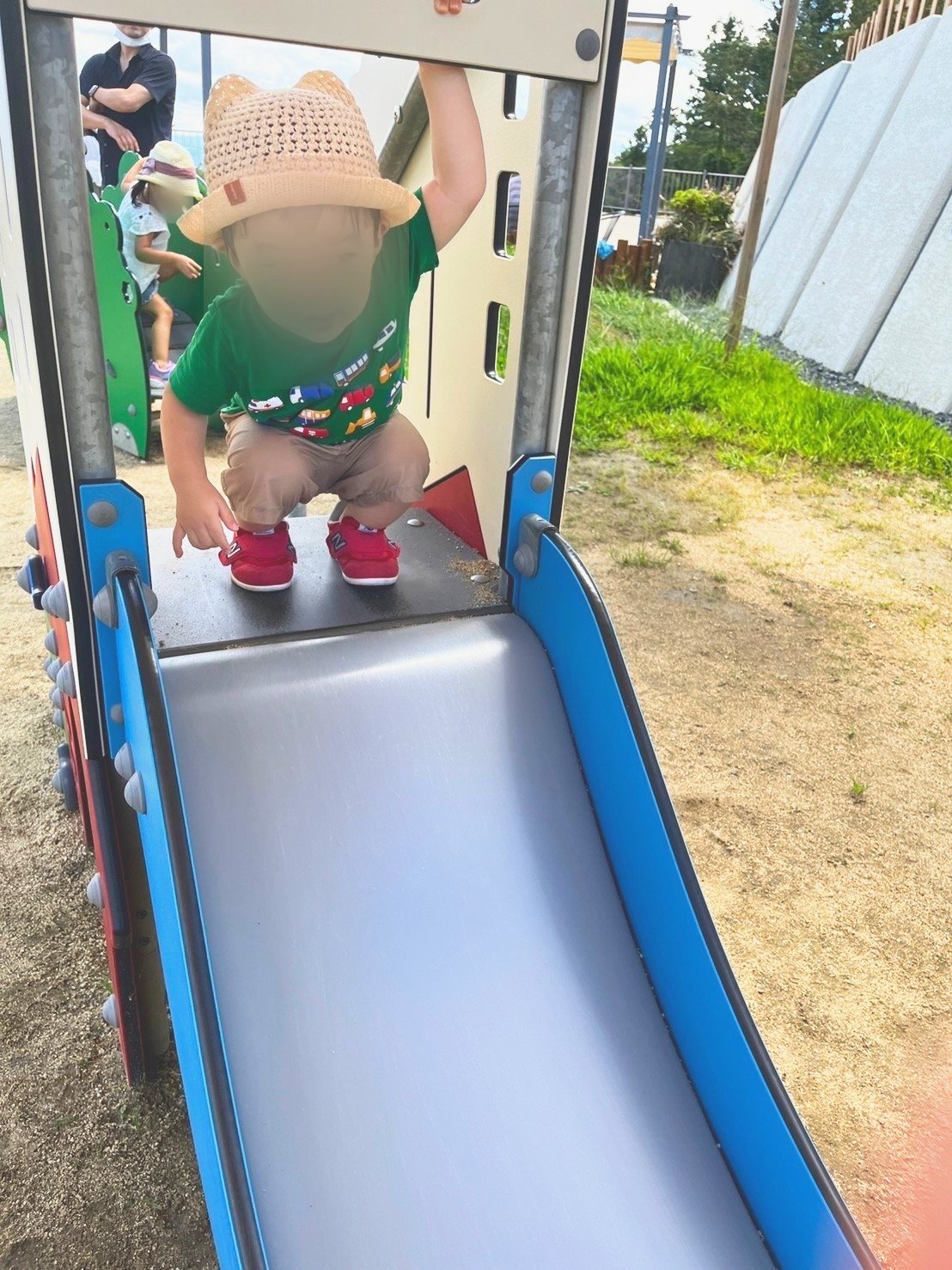 低い滑り台をのぼる子ども