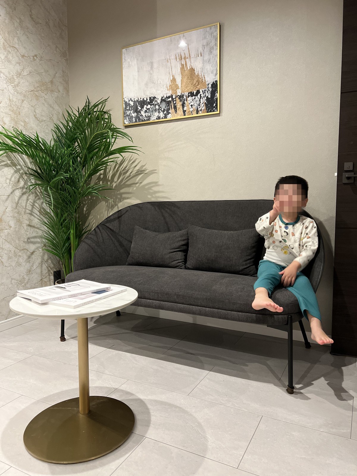 観葉植物と絵のある一角に置かれたソファとサイドテーブル