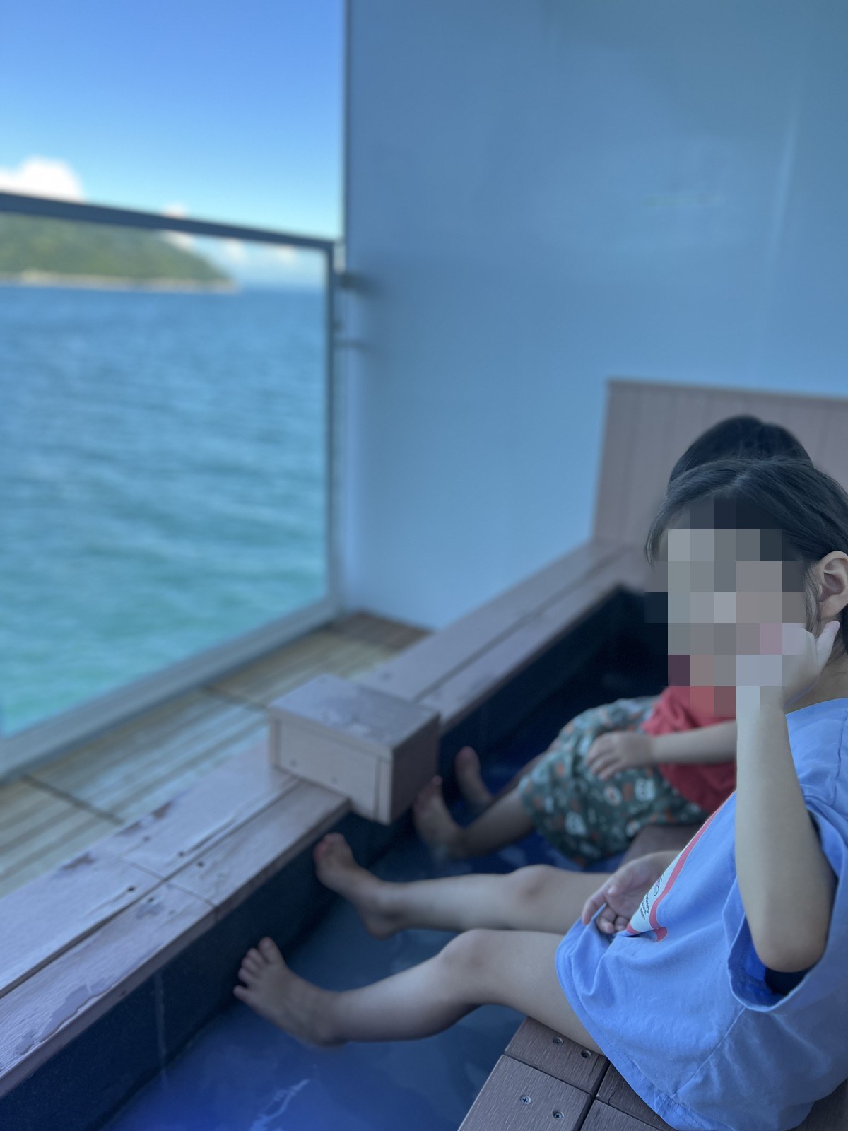 窓際の足湯に足をつけて座る子ども