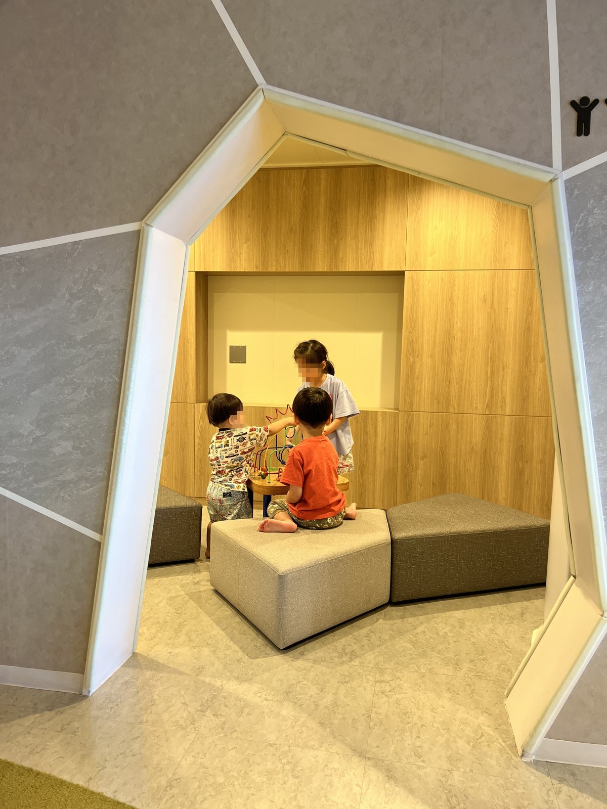 丸窓風の壁のくぼみに座る子どもたち