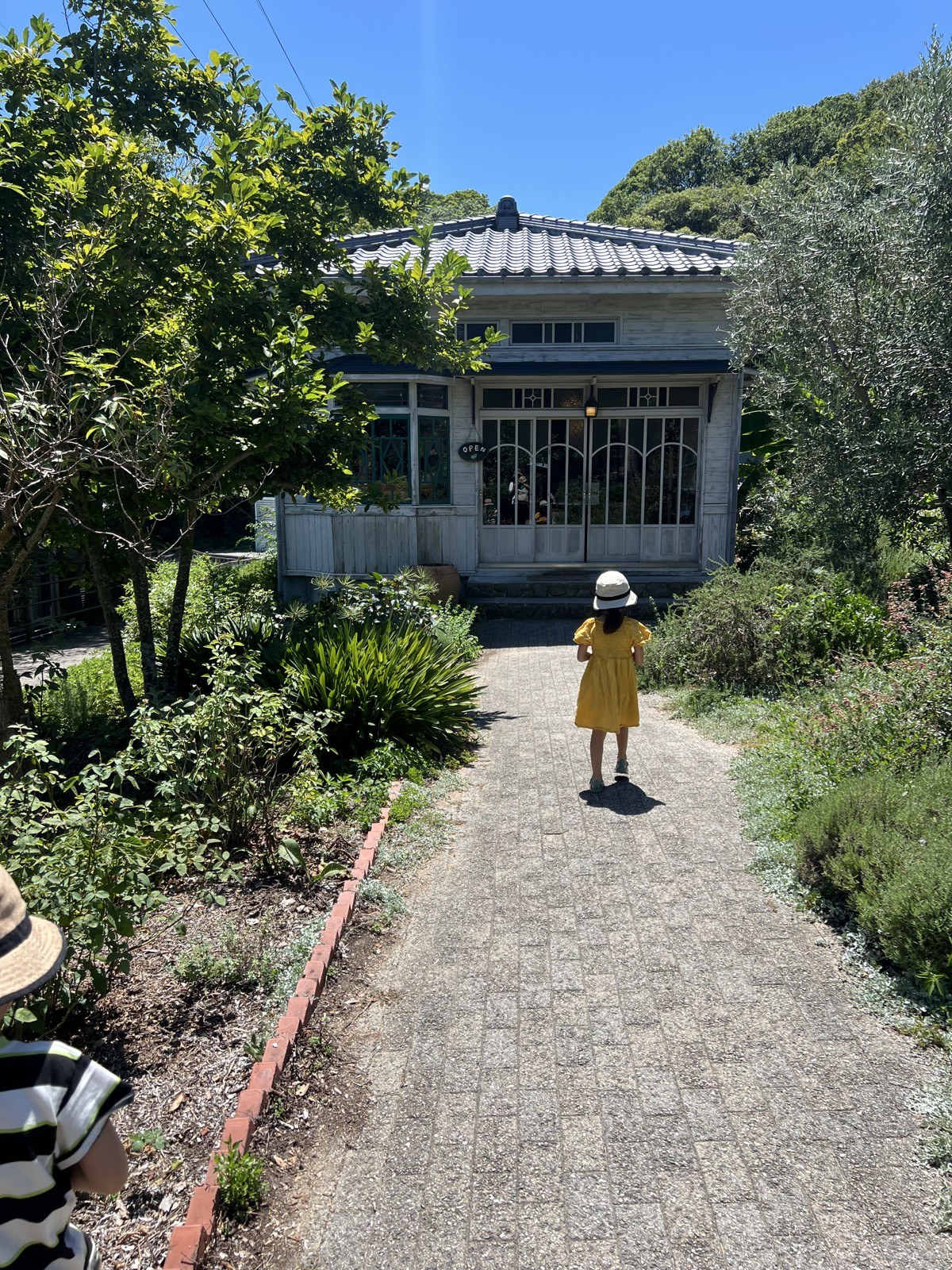 木立の奥に建つ白い洋館。OPENの札が下がっている