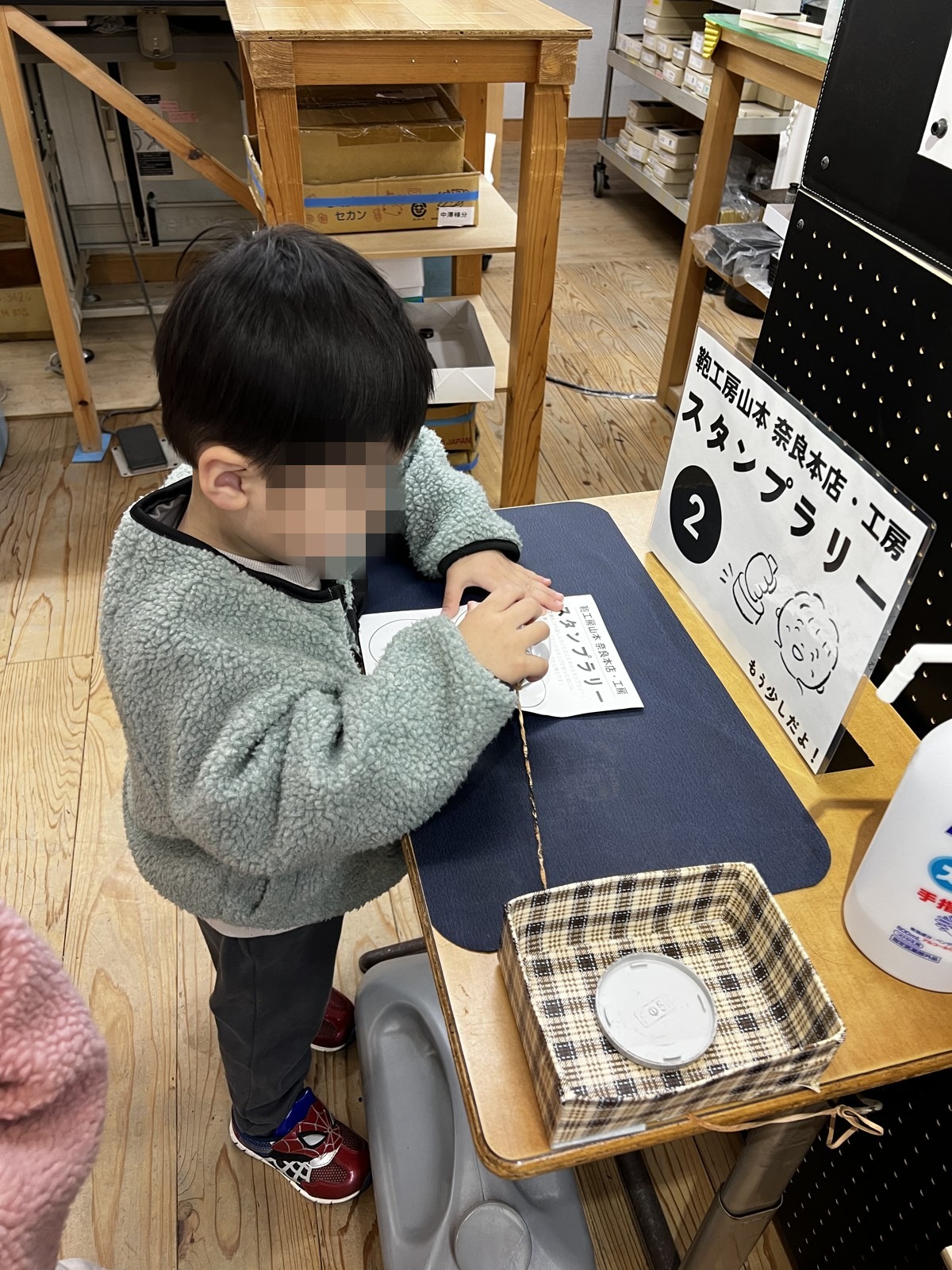 スタンプラリーの用紙に書き込む子ども
