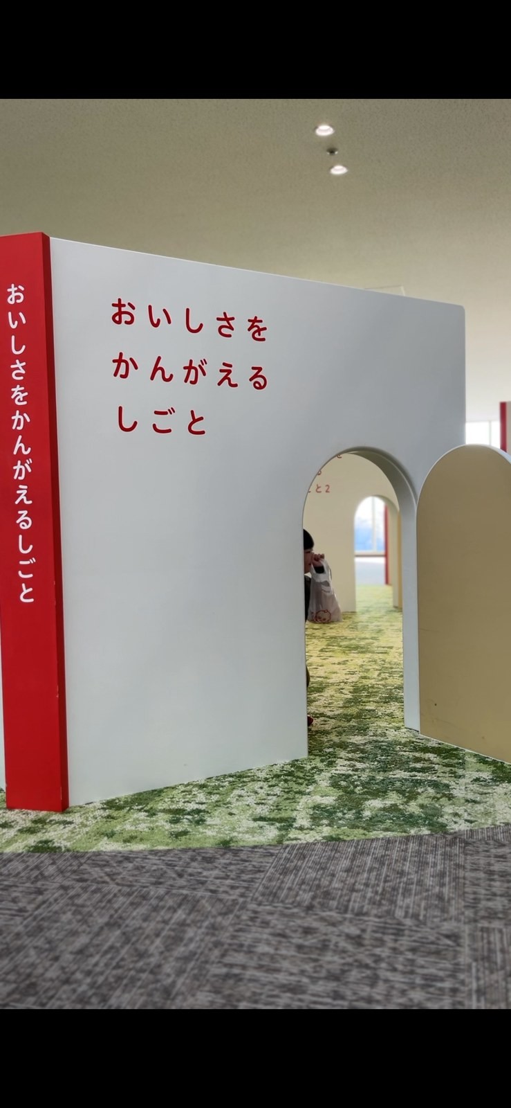 「おいしさをかんがえるしごと」と書かれた入口のアーチ