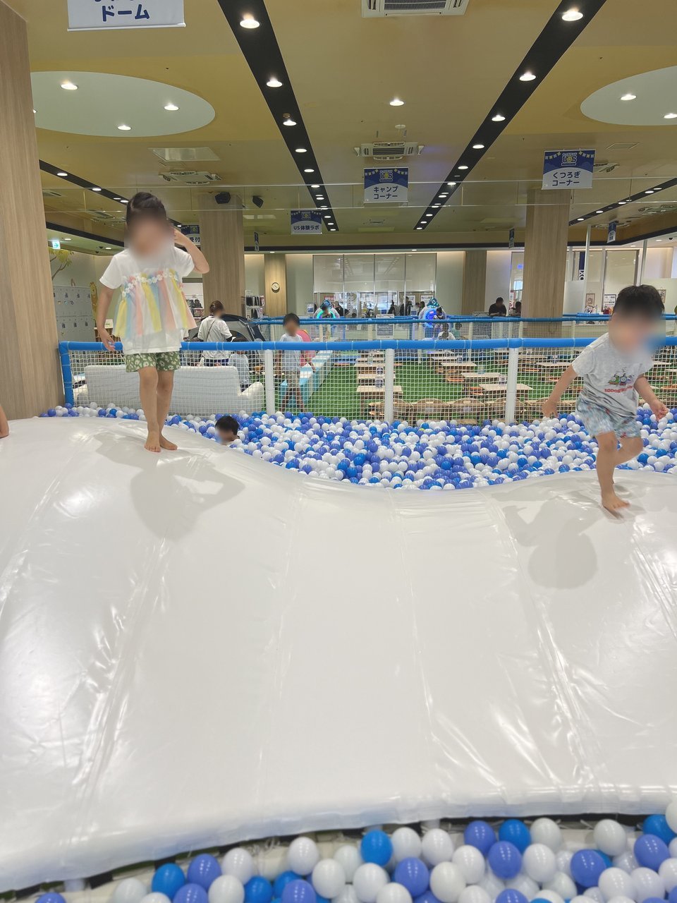 ボールプールの横の白いふわふわドームで跳ねる子どもたち