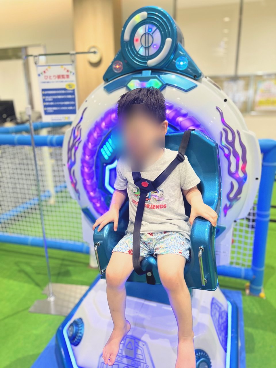 宇宙船のような乗り物に乗って笑う子ども