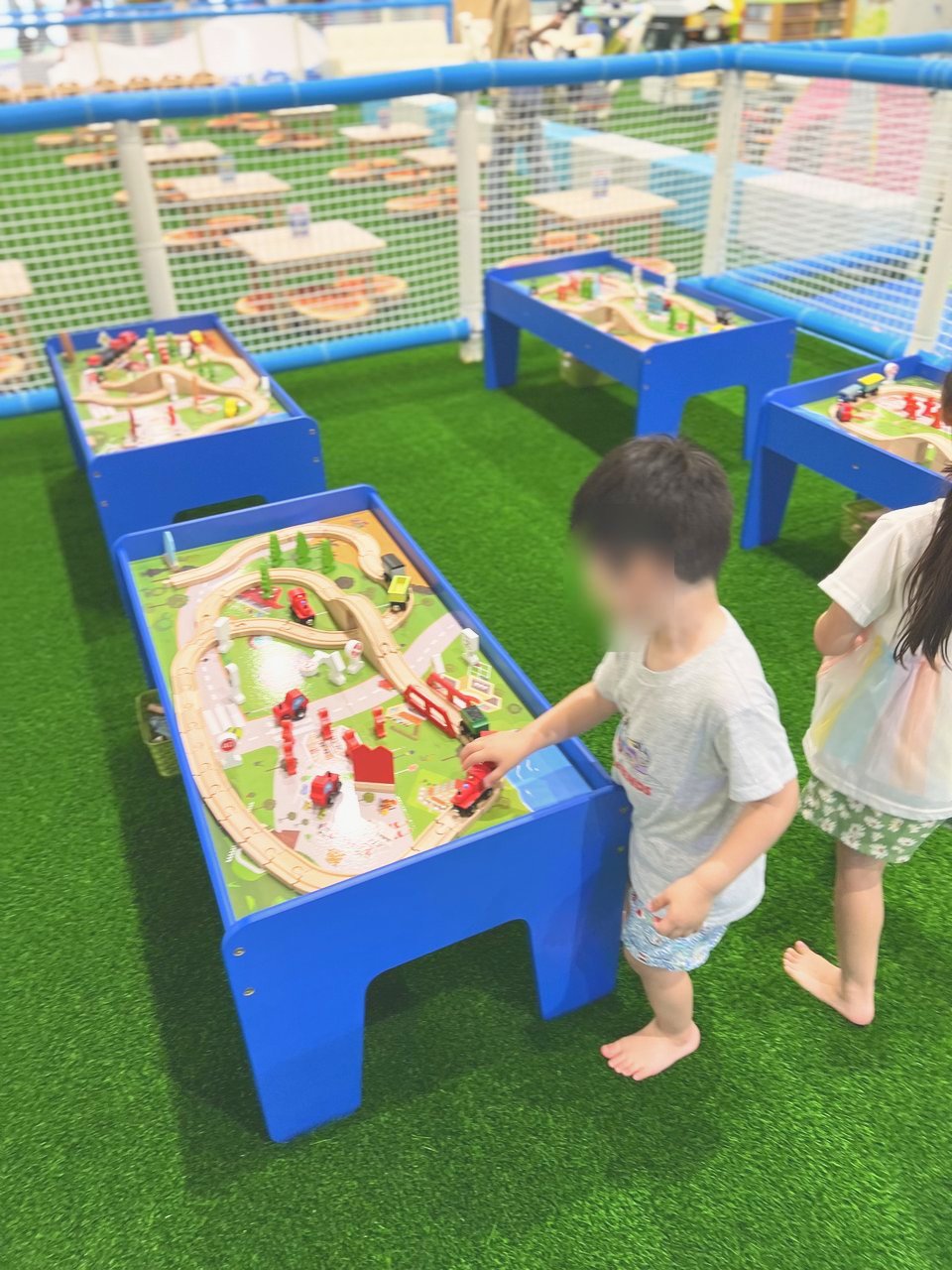 木の線路のおもちゃで遊ぶ子どもたち