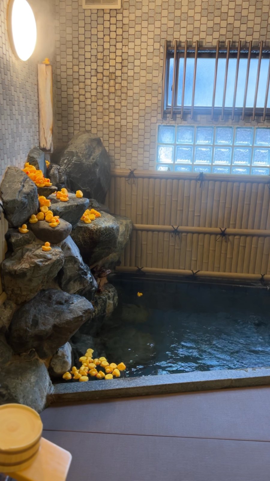 岩から流れる湯とあひるがたくさん浮かぶ貸切風呂