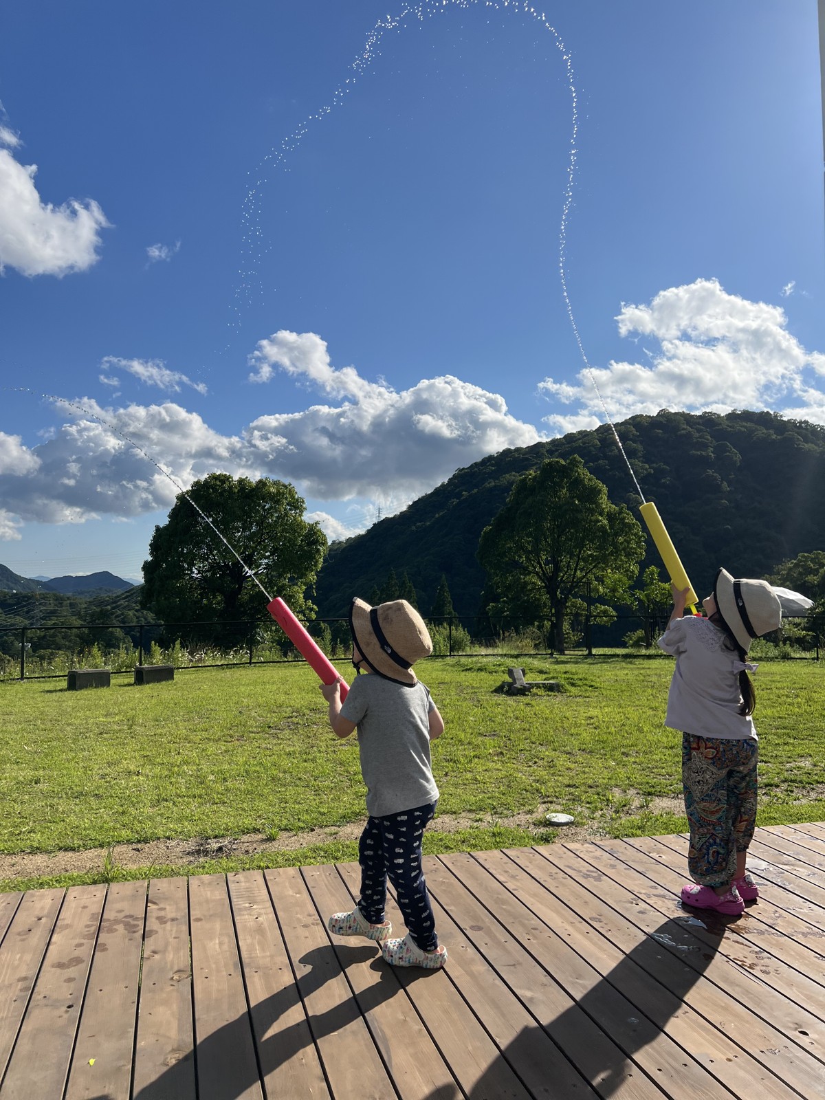 ウッドデッキでシャボン玉をする子どもたち
