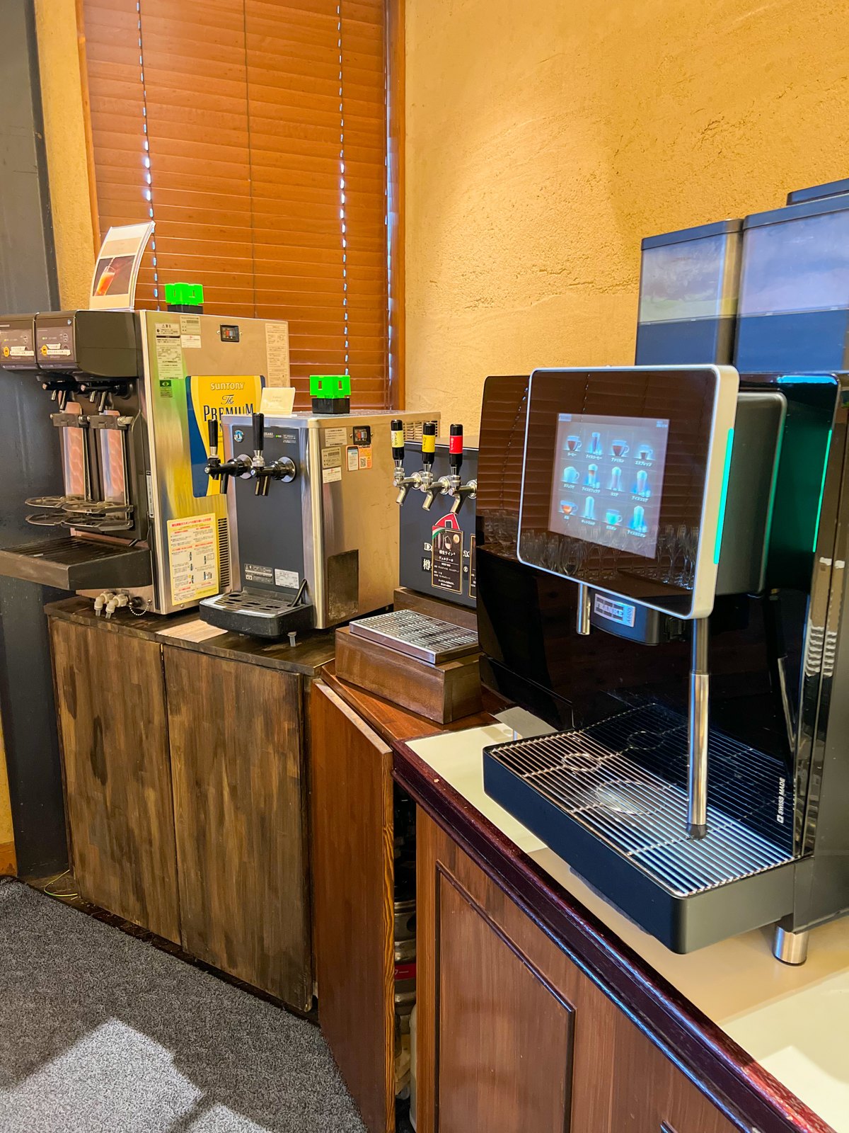 サントリーのビールサーバーや樽生ワイン、コーヒーマシンが並ぶドリンクコーナー