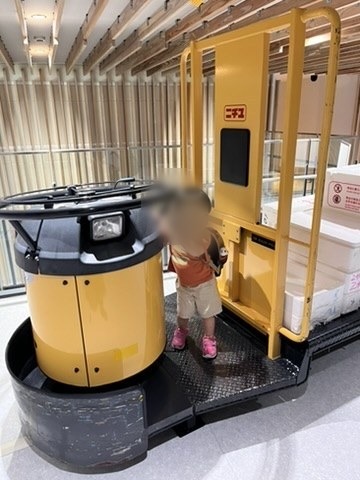 市場の運搬車の運転席に座る子ども