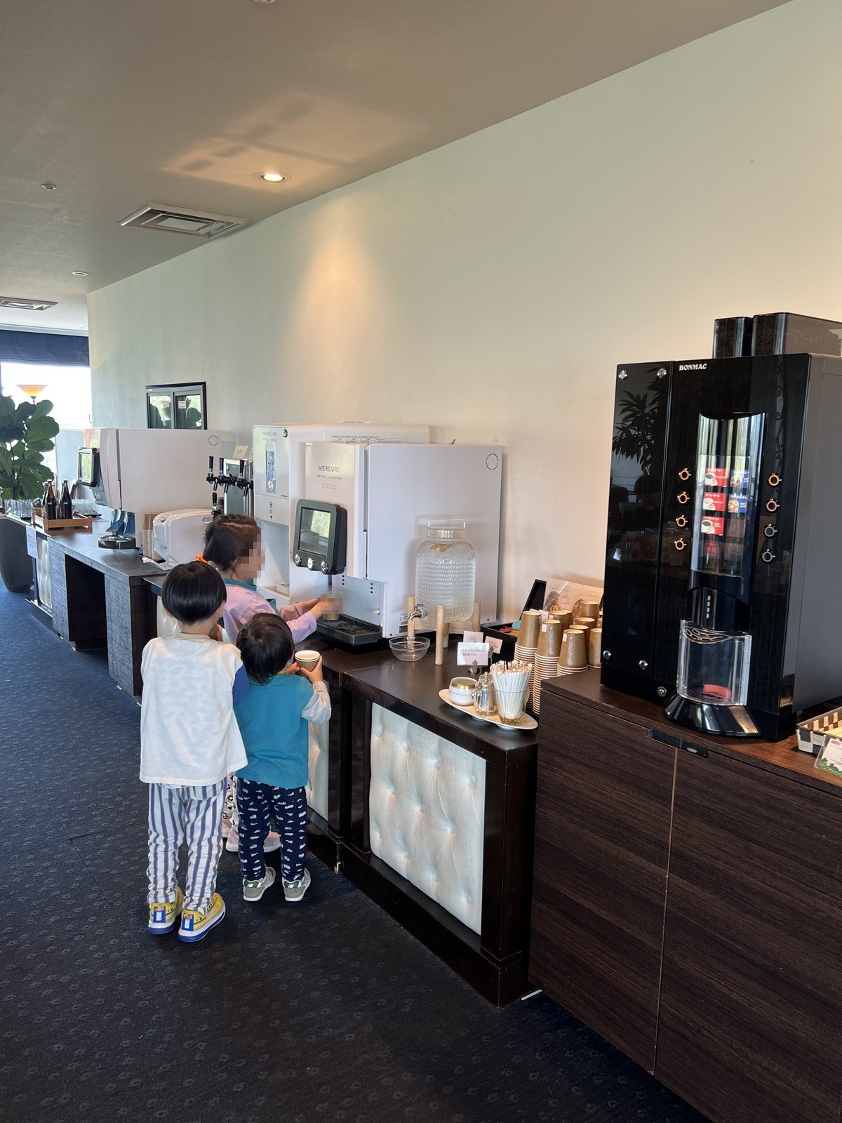 ラウンジのドリンクマシンに並ぶ、作務衣姿の子どもたち
