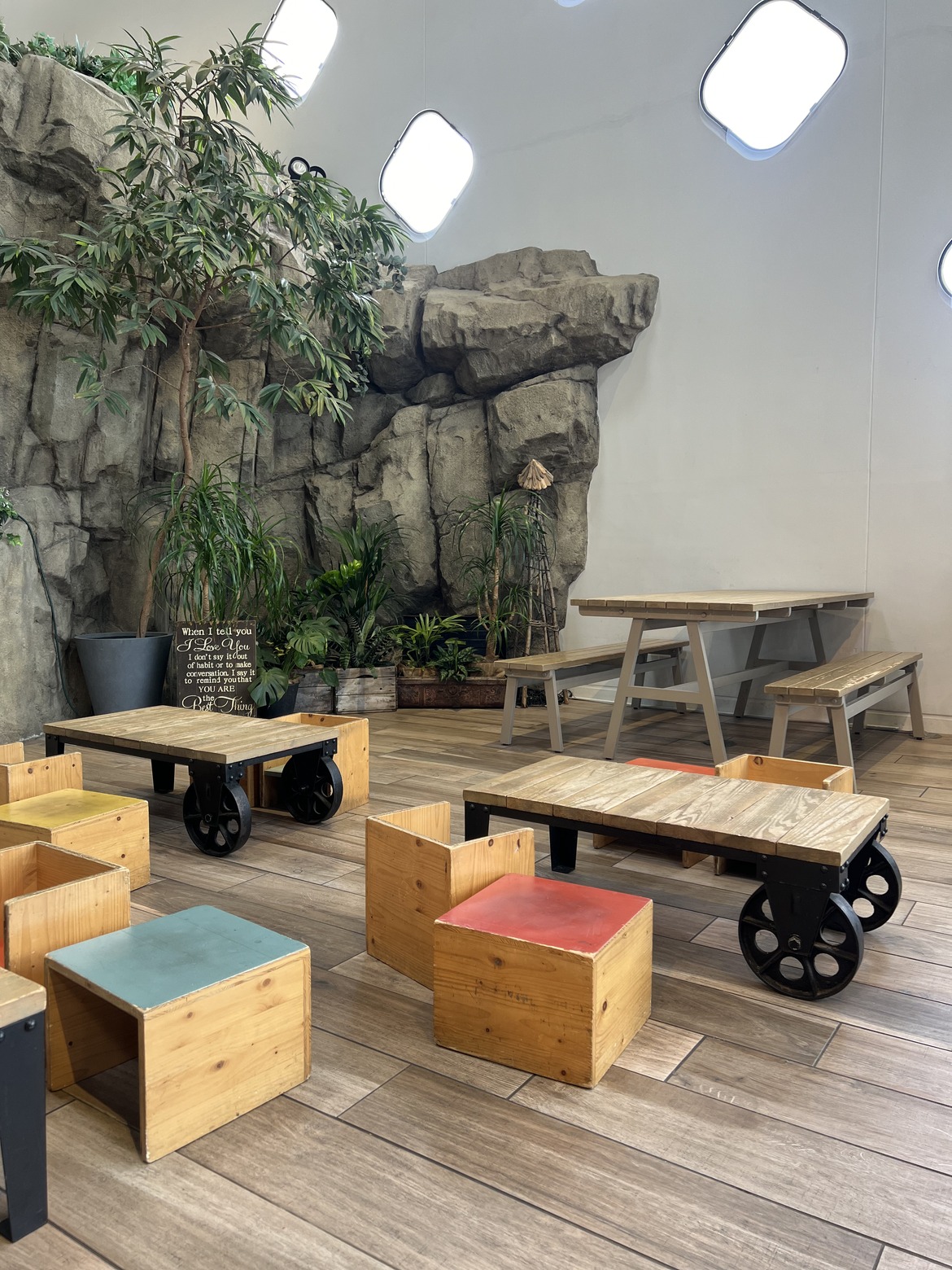 岩の壁に面した木のテーブルとベンチ