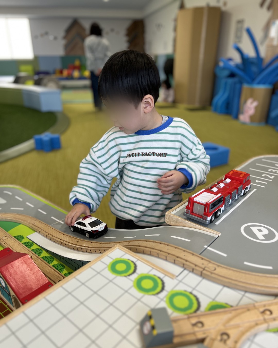 ミニカーを走らせて遊ぶ子ども
