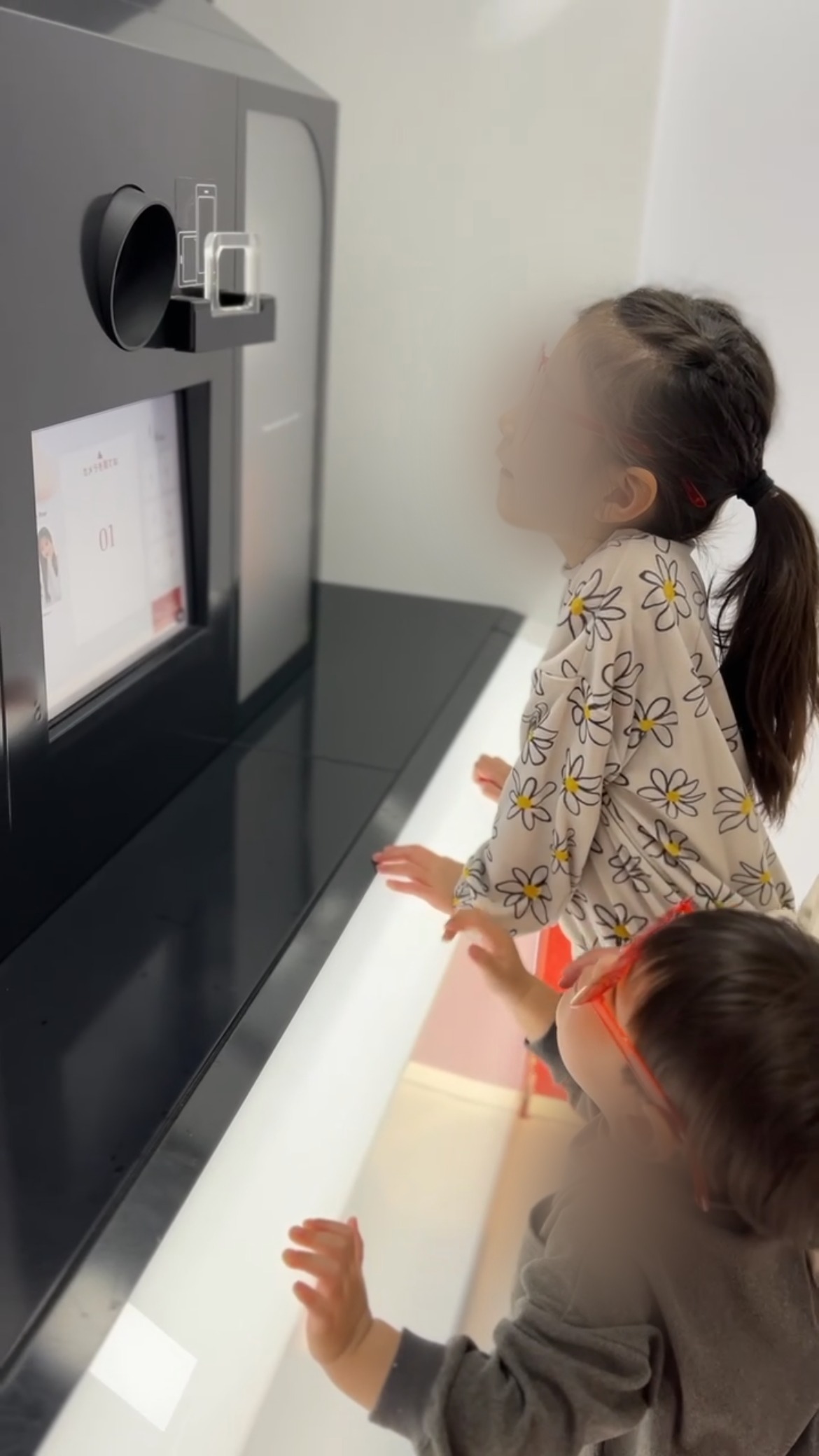 プリクラの機械の前に並ぶ子どもたち