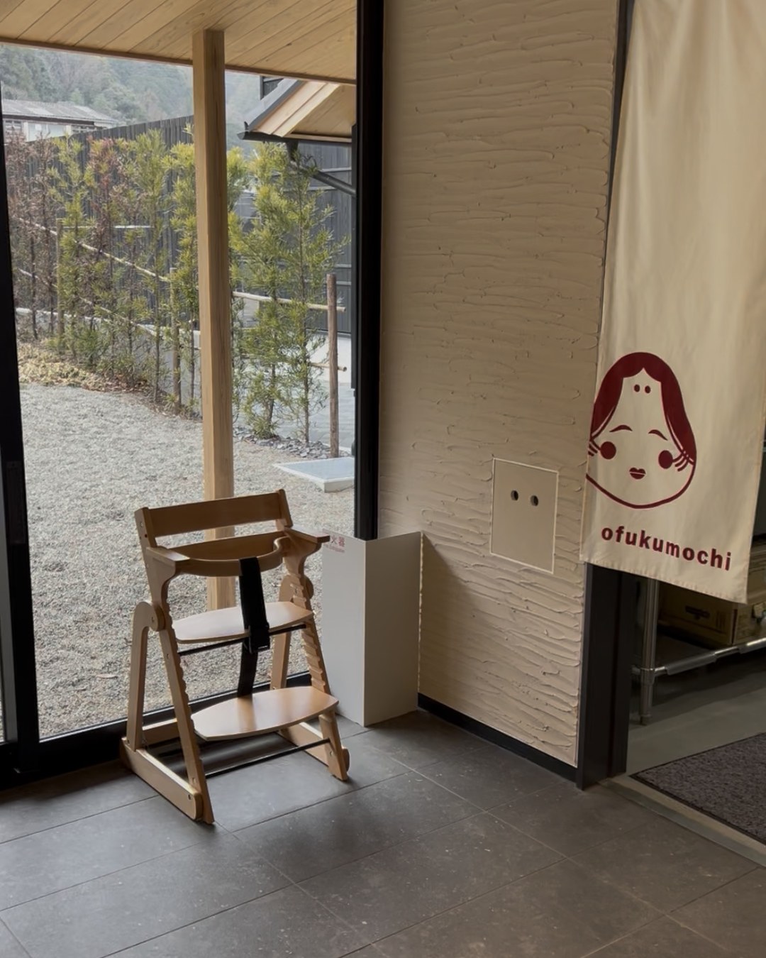 入口に置かれた木製の子ども用ハイチェア