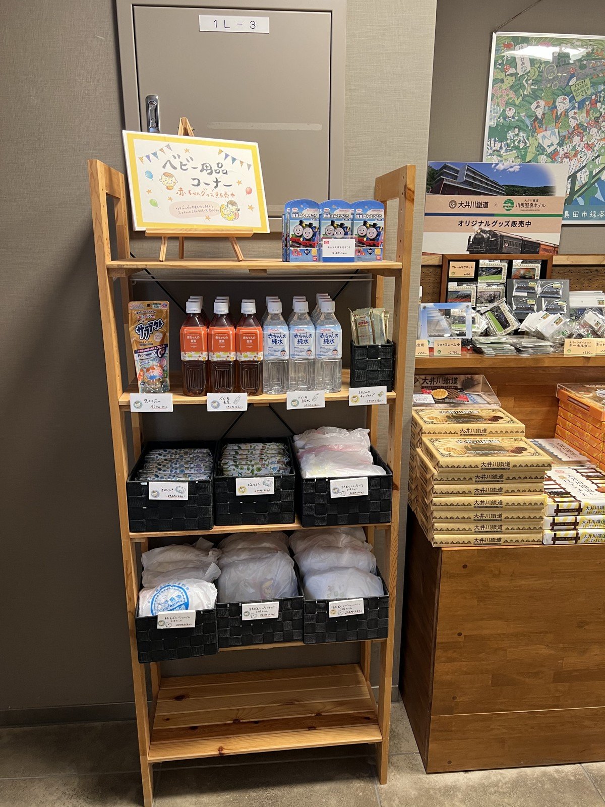 「ベビー用品コーナー」の棚。赤ちゃんの麦茶・純水、おしりふき、紙おむつなど