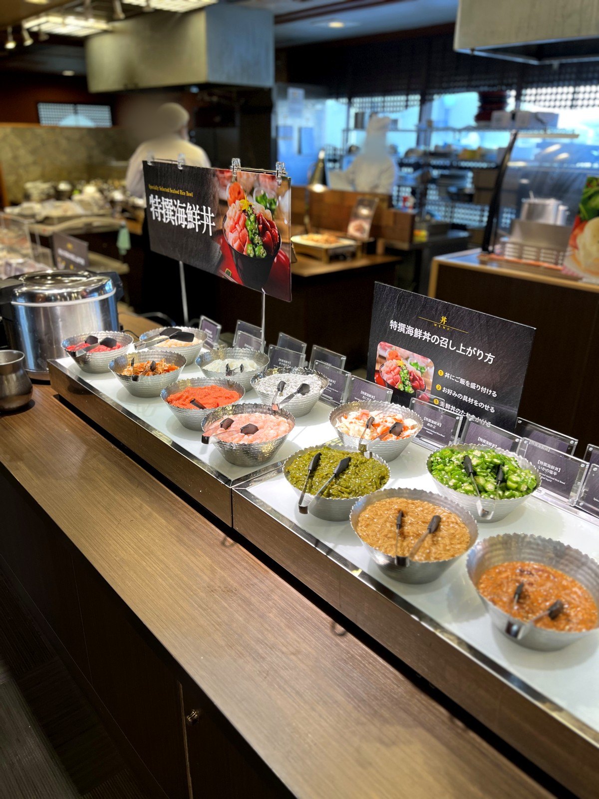「特撰海鮮丼」のコーナー。マグロやサーモン、エビ、ネバネバ食材などの具材が並ぶ