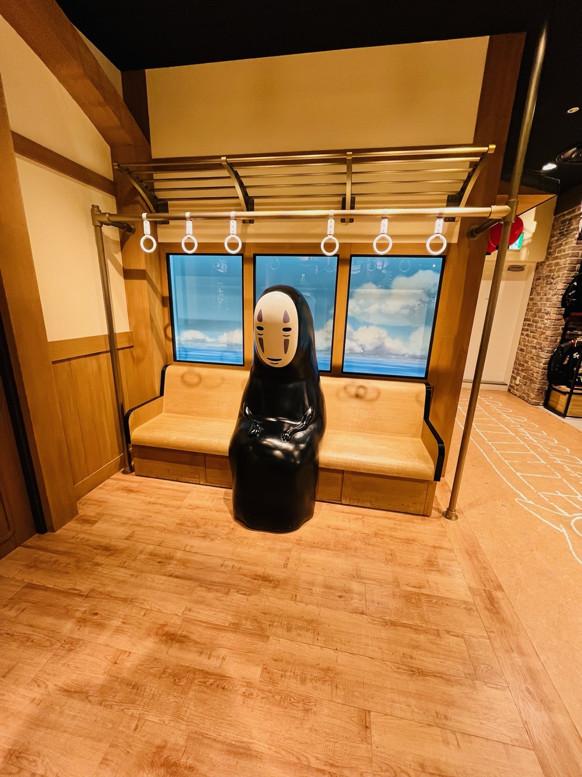 電車の座席を模したベンチと黒い立体像