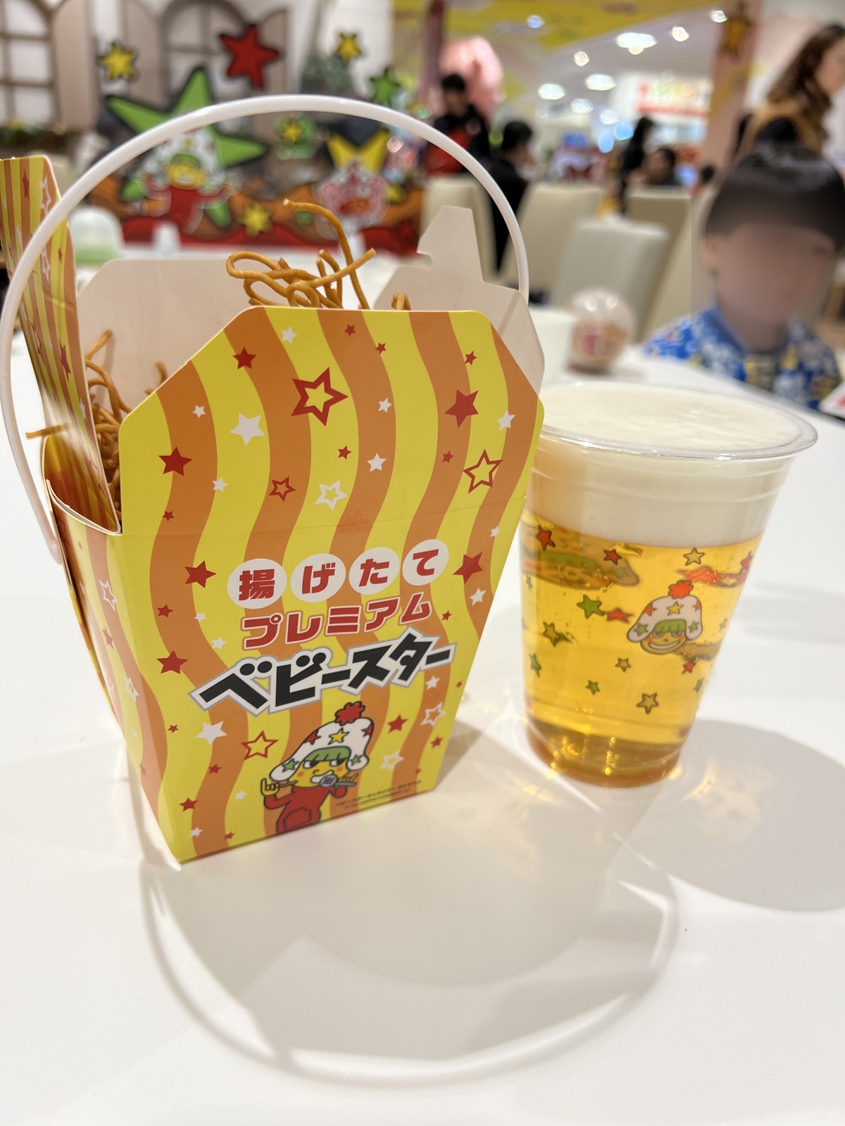 星型のカップに入った揚げたてプレミアムベビースターとドリンク