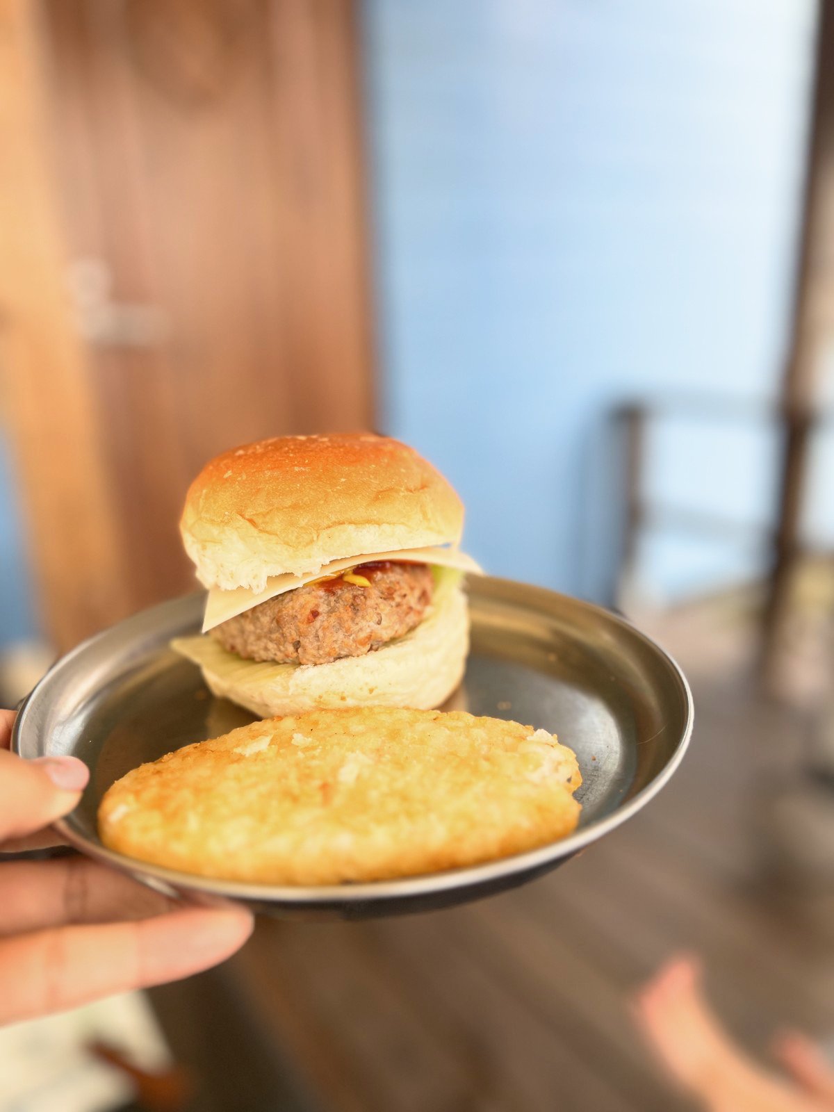 バンズにハンバーグを挟んだバーガーとハッシュドポテト