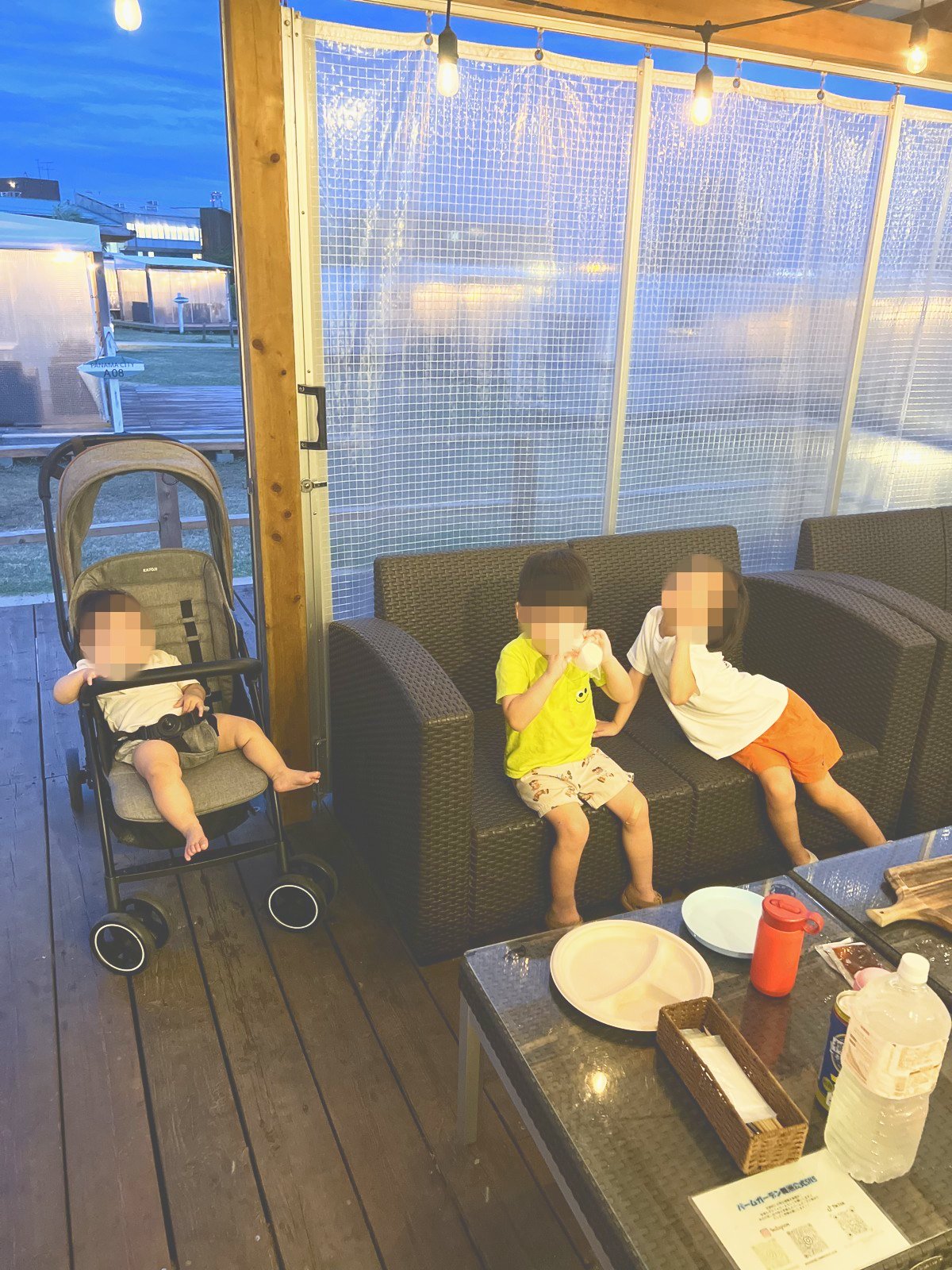 ソファに座ってごはんを食べる子どもたちと、ベビーカーの赤ちゃん