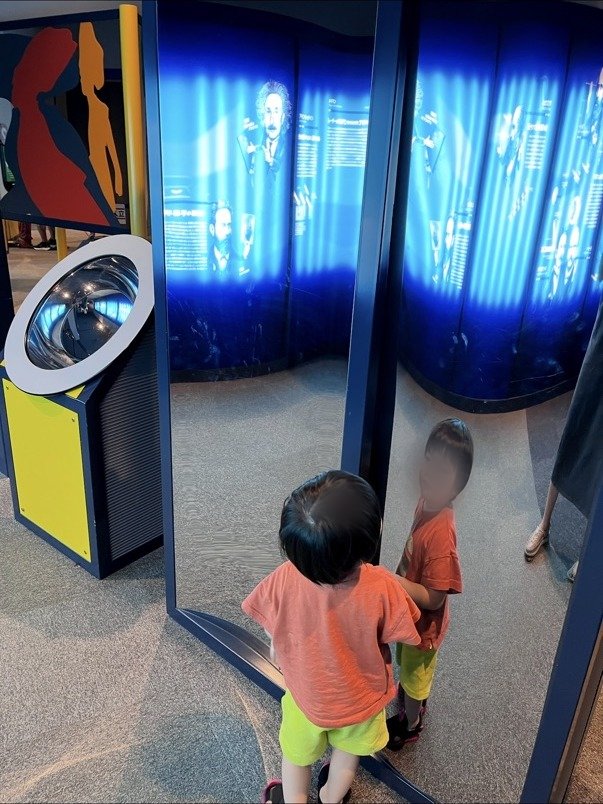 鏡の展示の前に立つ子ども
