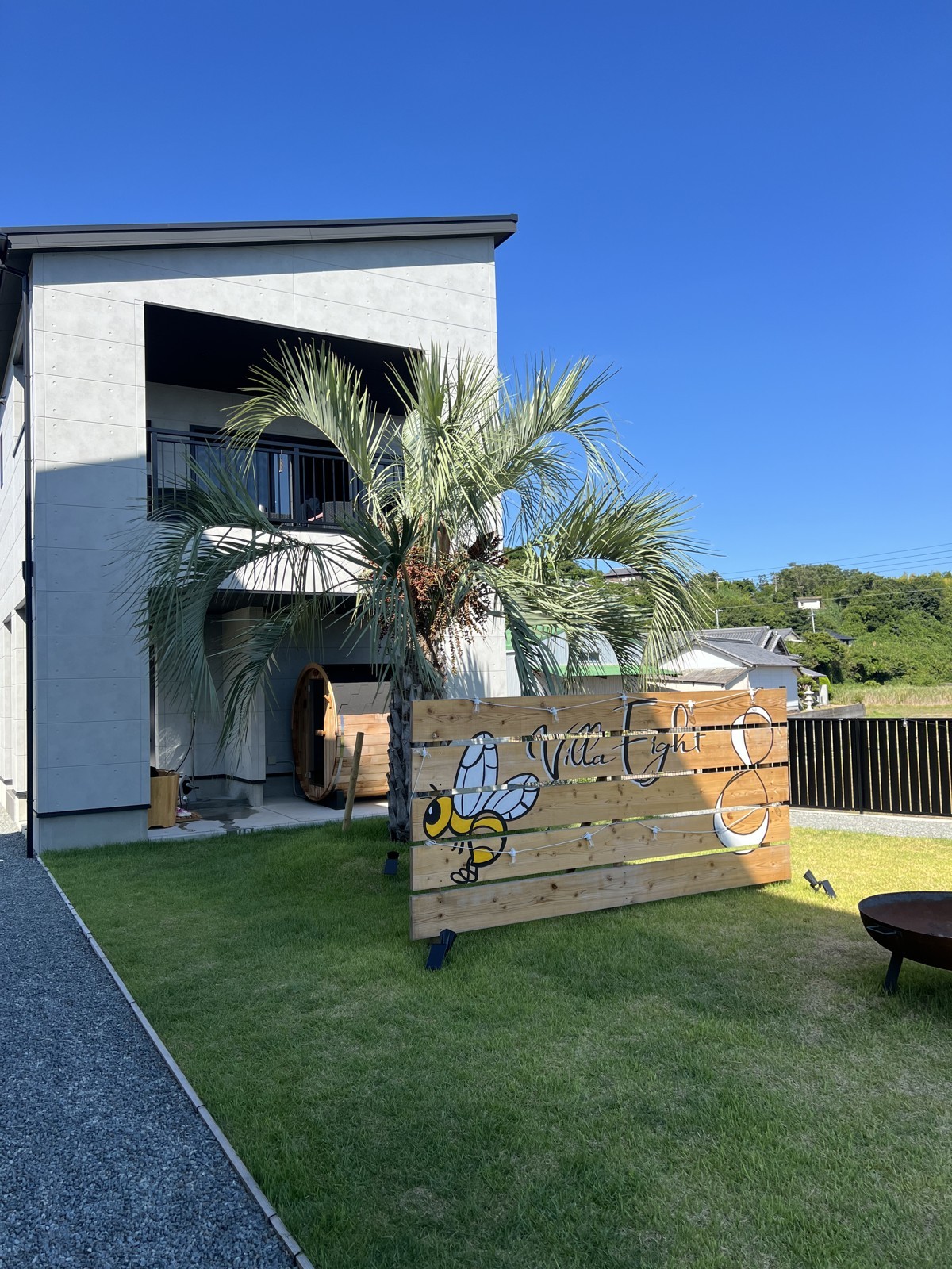 芝生の庭にVilla 8の看板とヤシの木がある外観