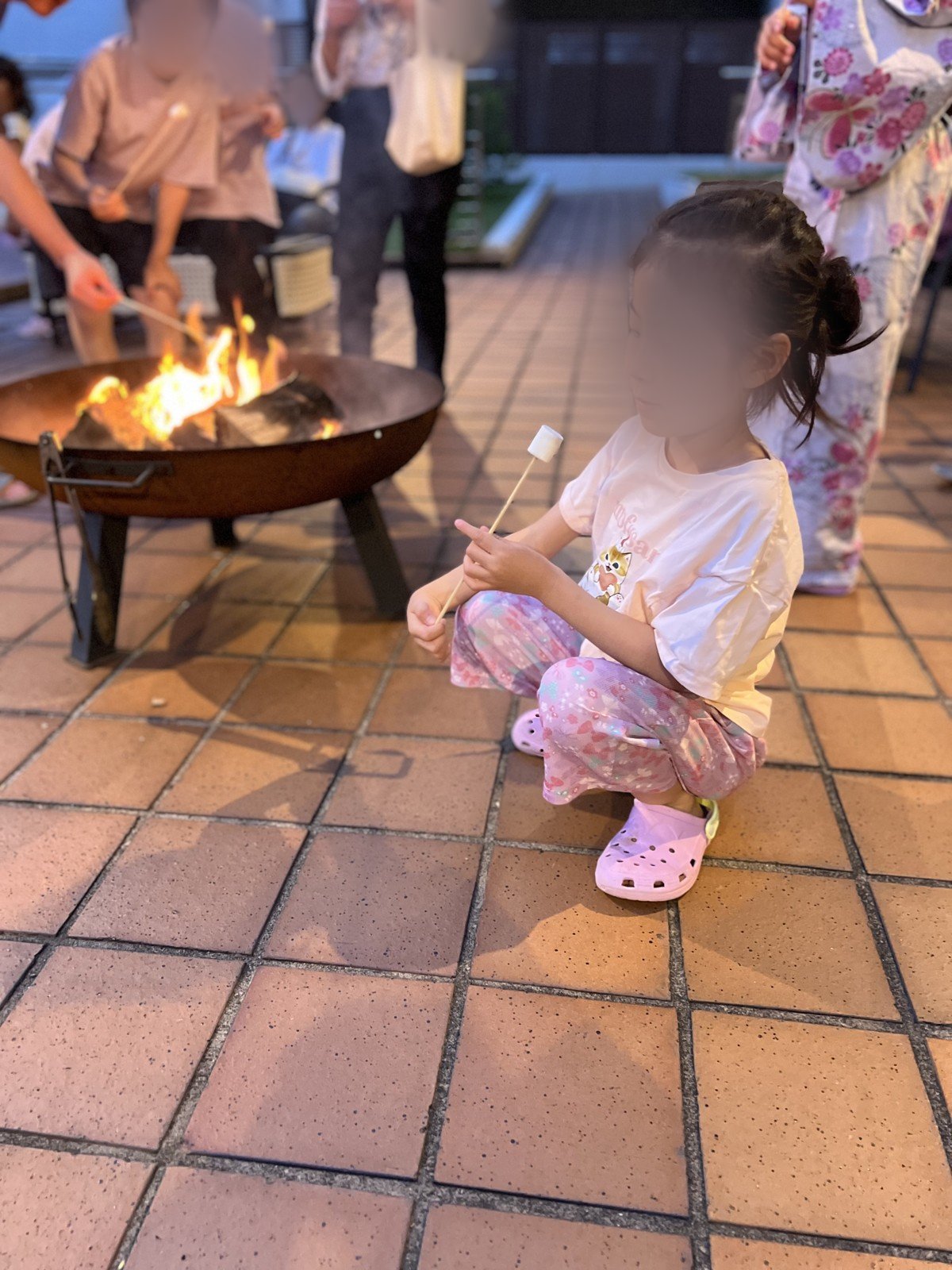 焚き火でマシュマロを焼く娘