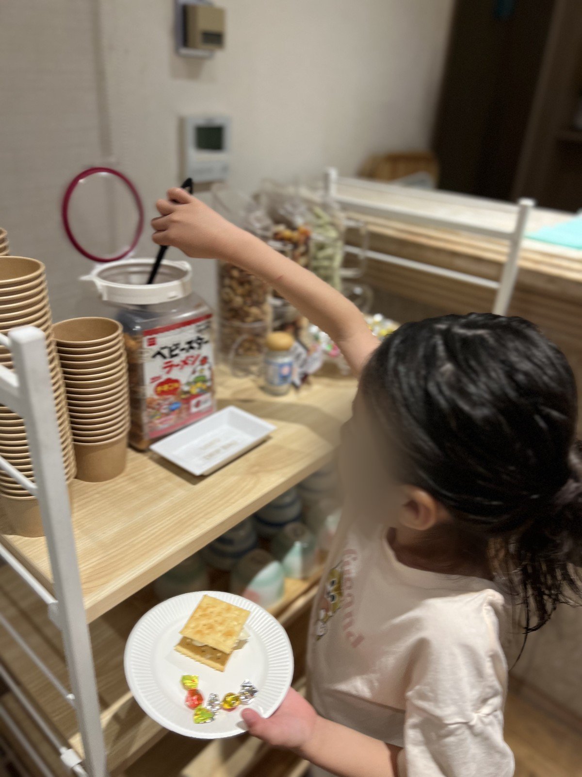 お菓子のコーナーでお菓子を選ぶ娘
