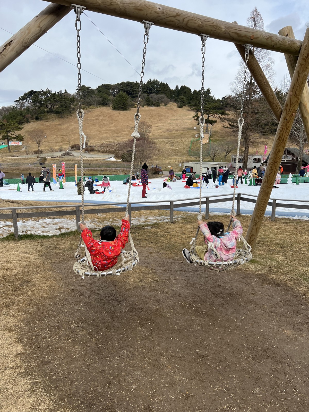 木のブランコと、奥に見えるゲレンデ