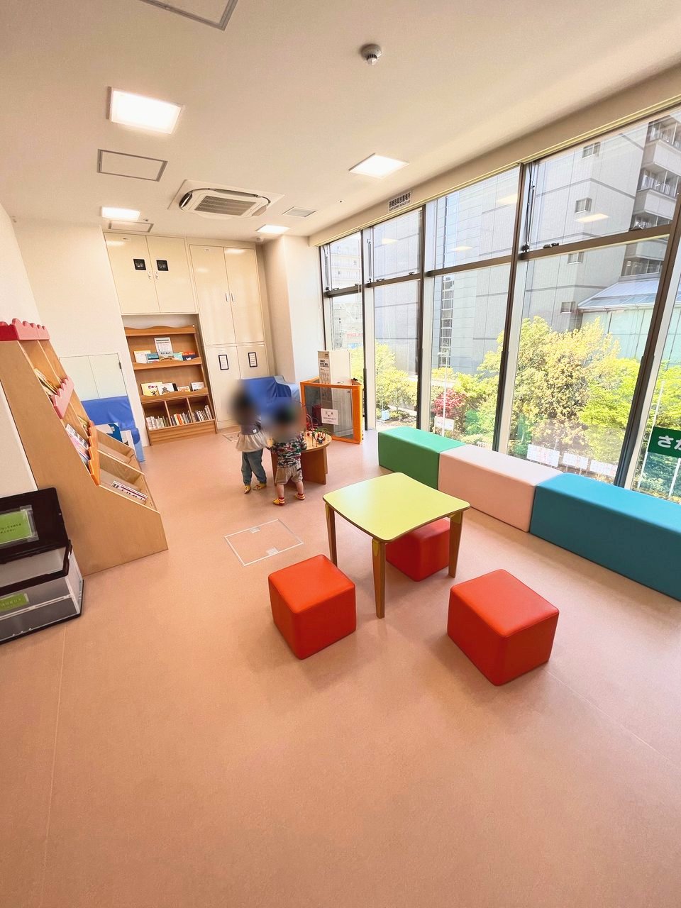 窓ぎわに長いベンチと小さなテーブルがあるお部屋