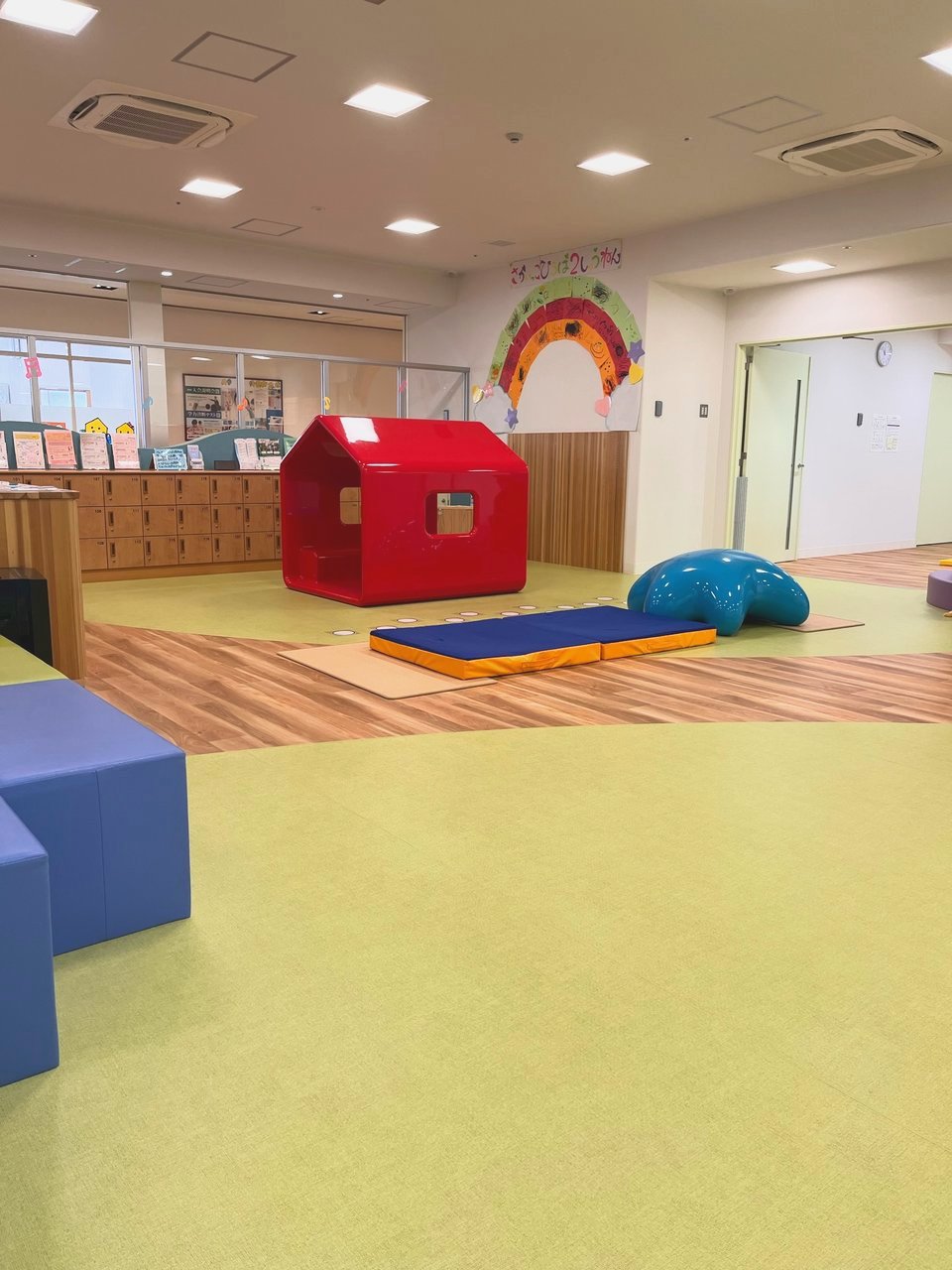 赤いおうちの遊具とヒトデの形の遊具がある、あそびの場