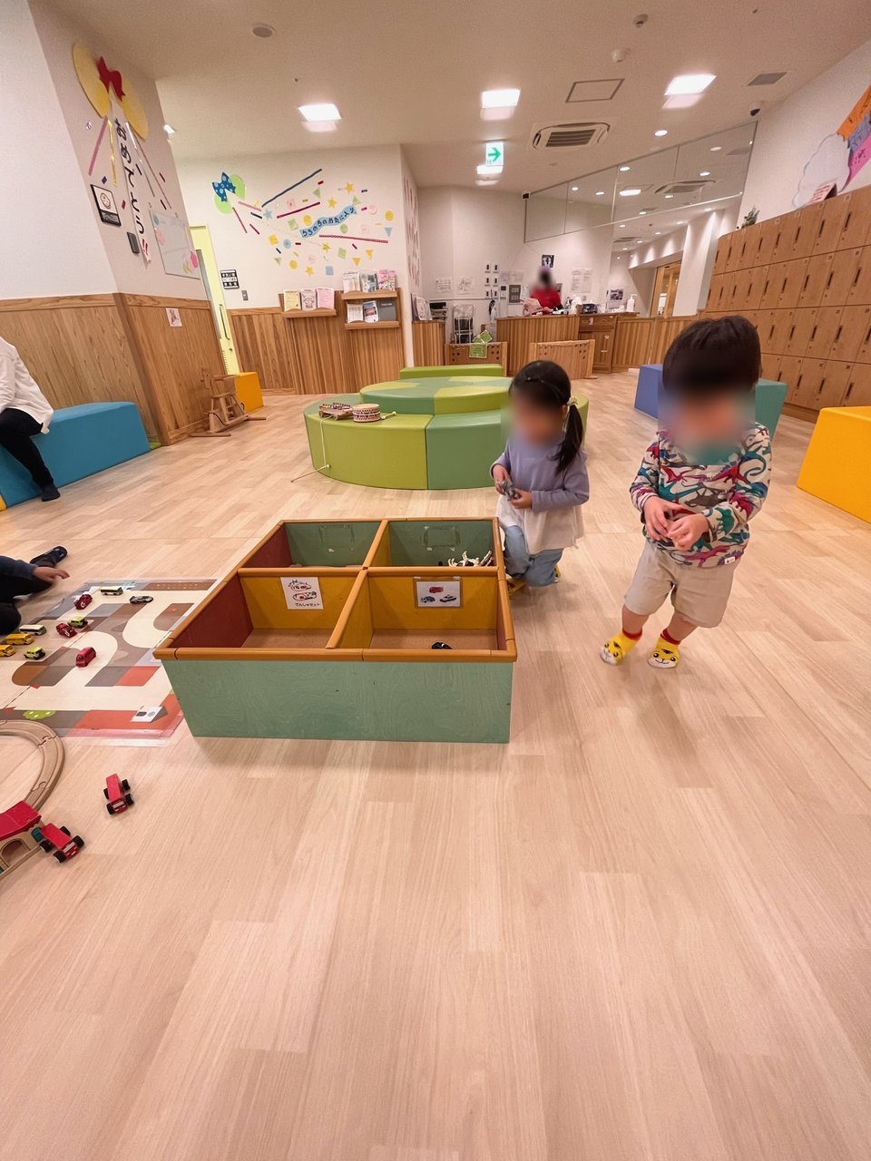 車のおもちゃの箱を囲んで遊ぶきょうだい